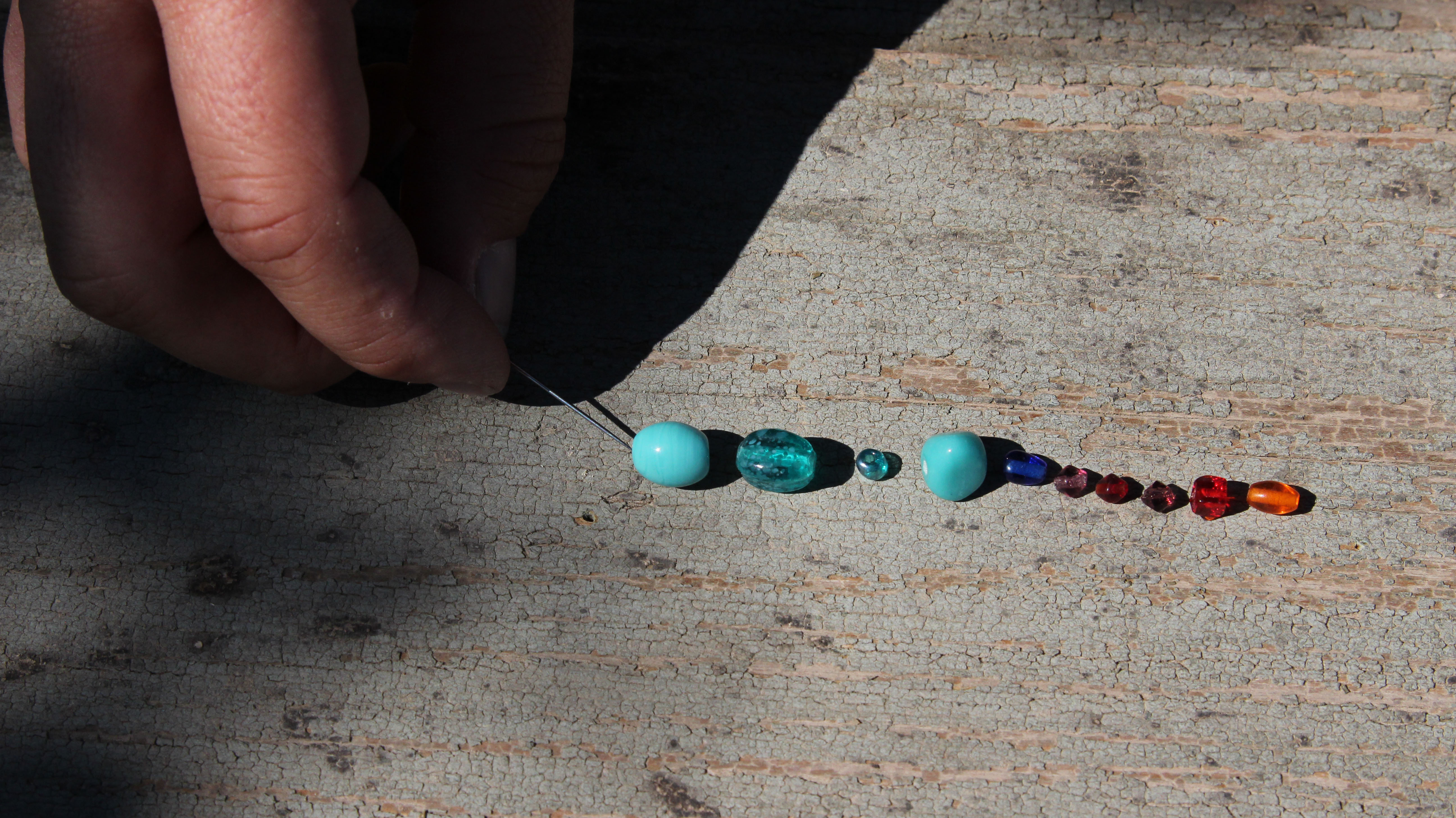 Perline infilate con un ago nel filo di nylon.