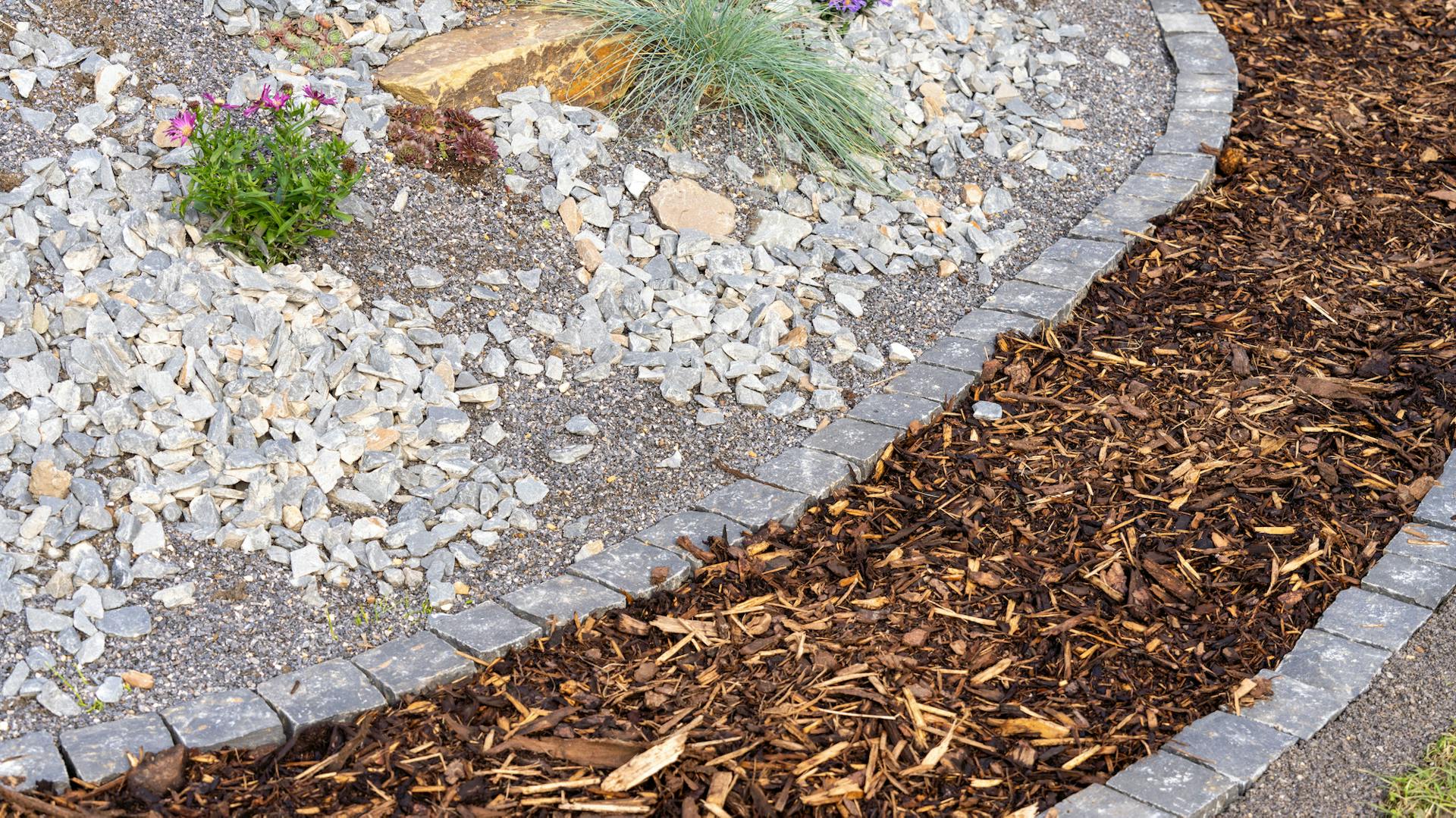 Schmaler Gartenweg mit Mulch und Steineinfassung