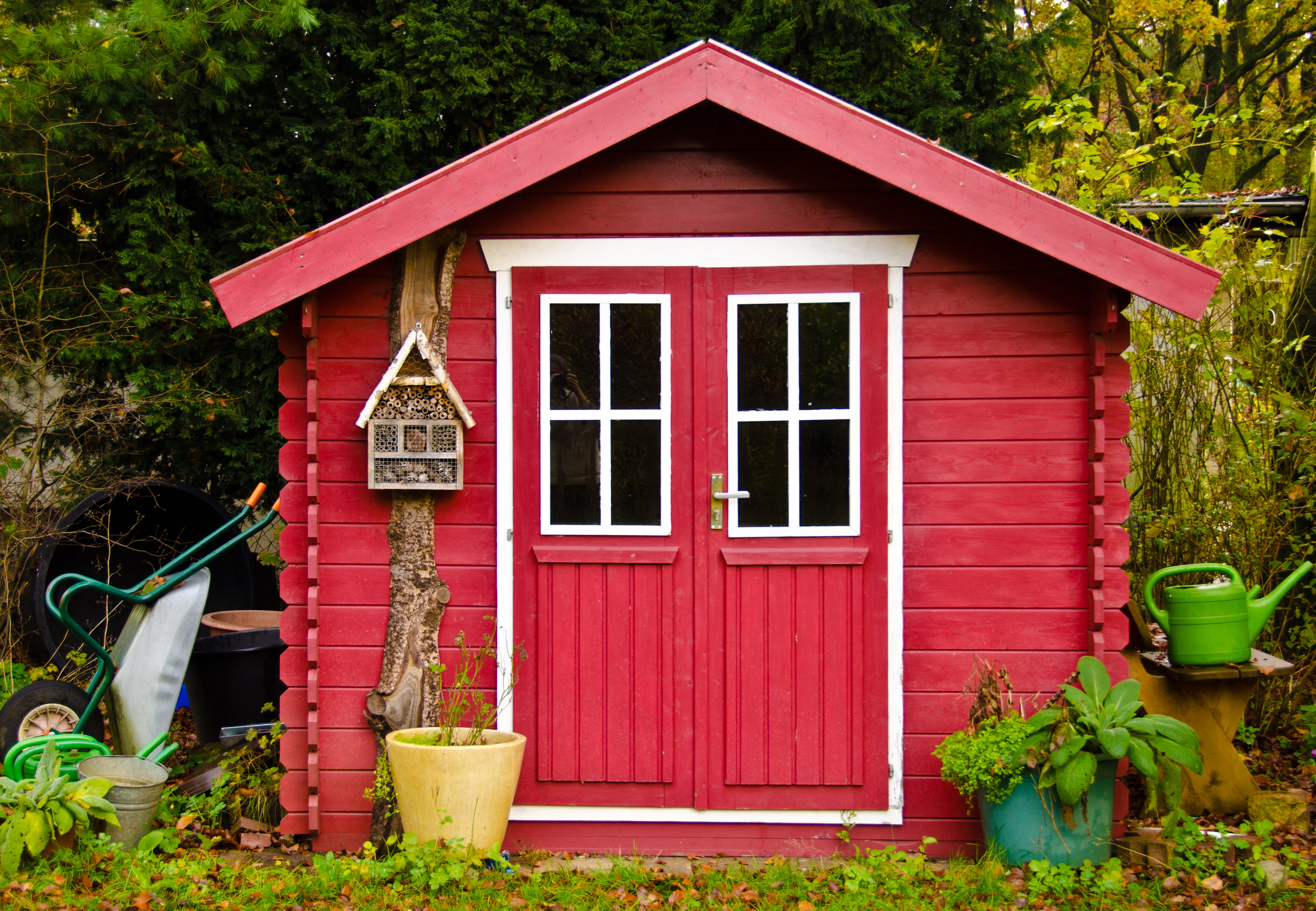 Rotes Gartenhaus mit Insektenhotel