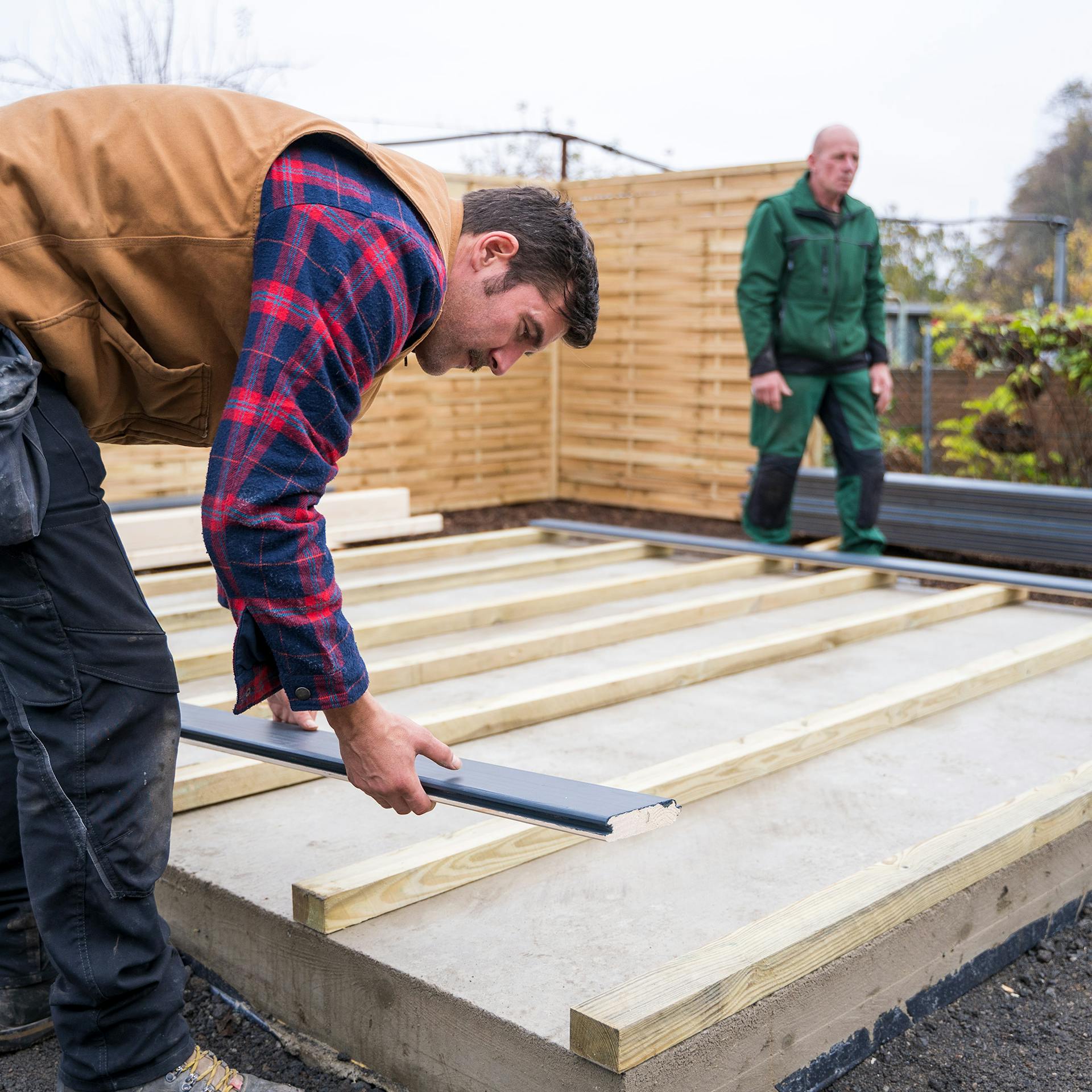 Két ember egy vázszerkezetet épít a kerti ház számára.