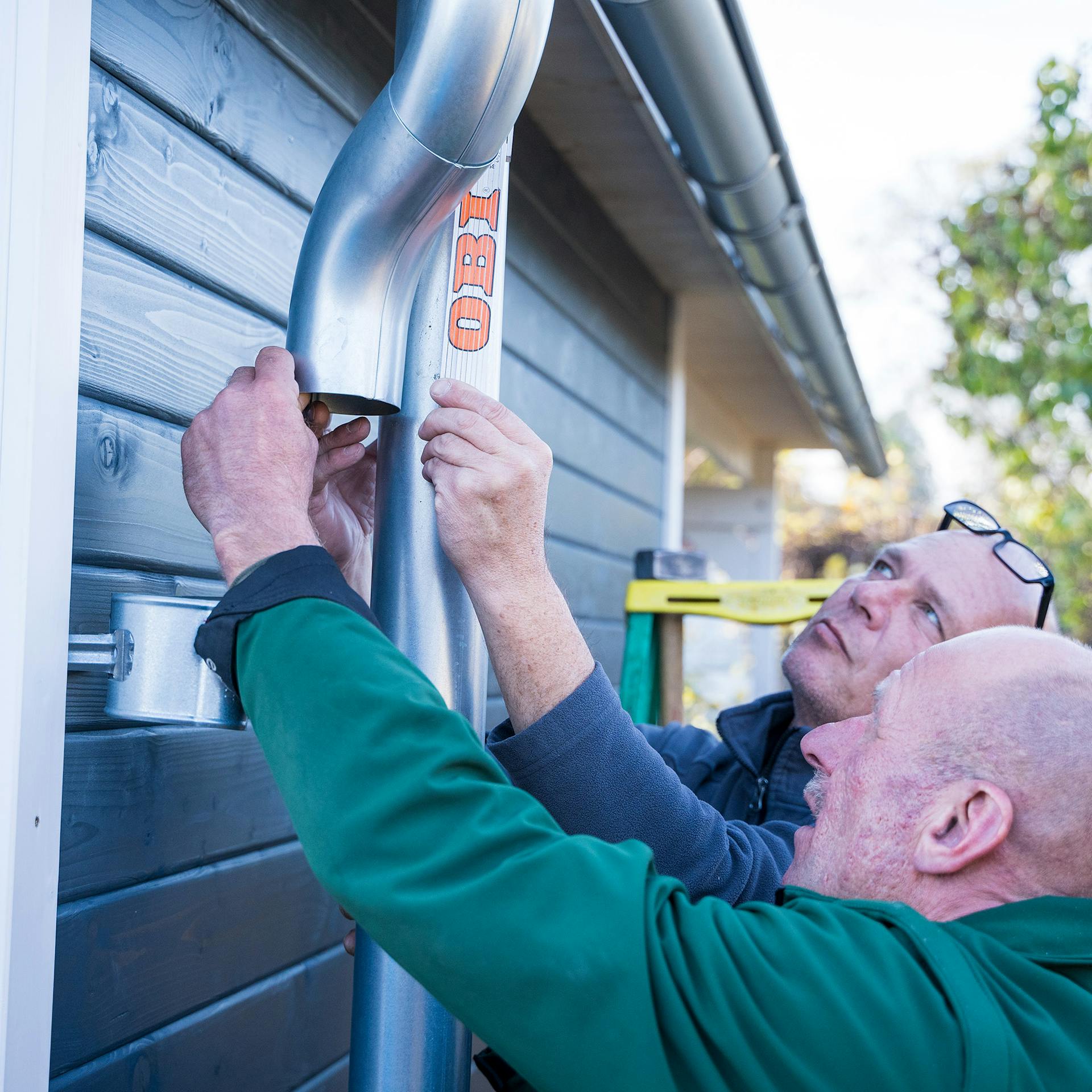 Két ember méretet vesz az ejtőcsőről.