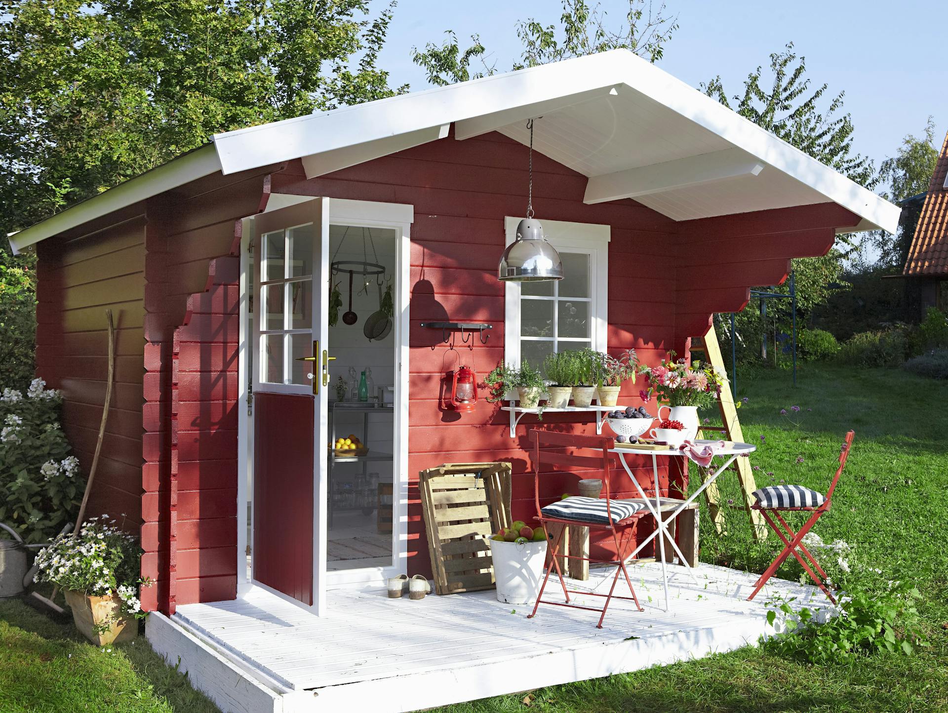 Rotes kleines Gartenhaus im Garten.