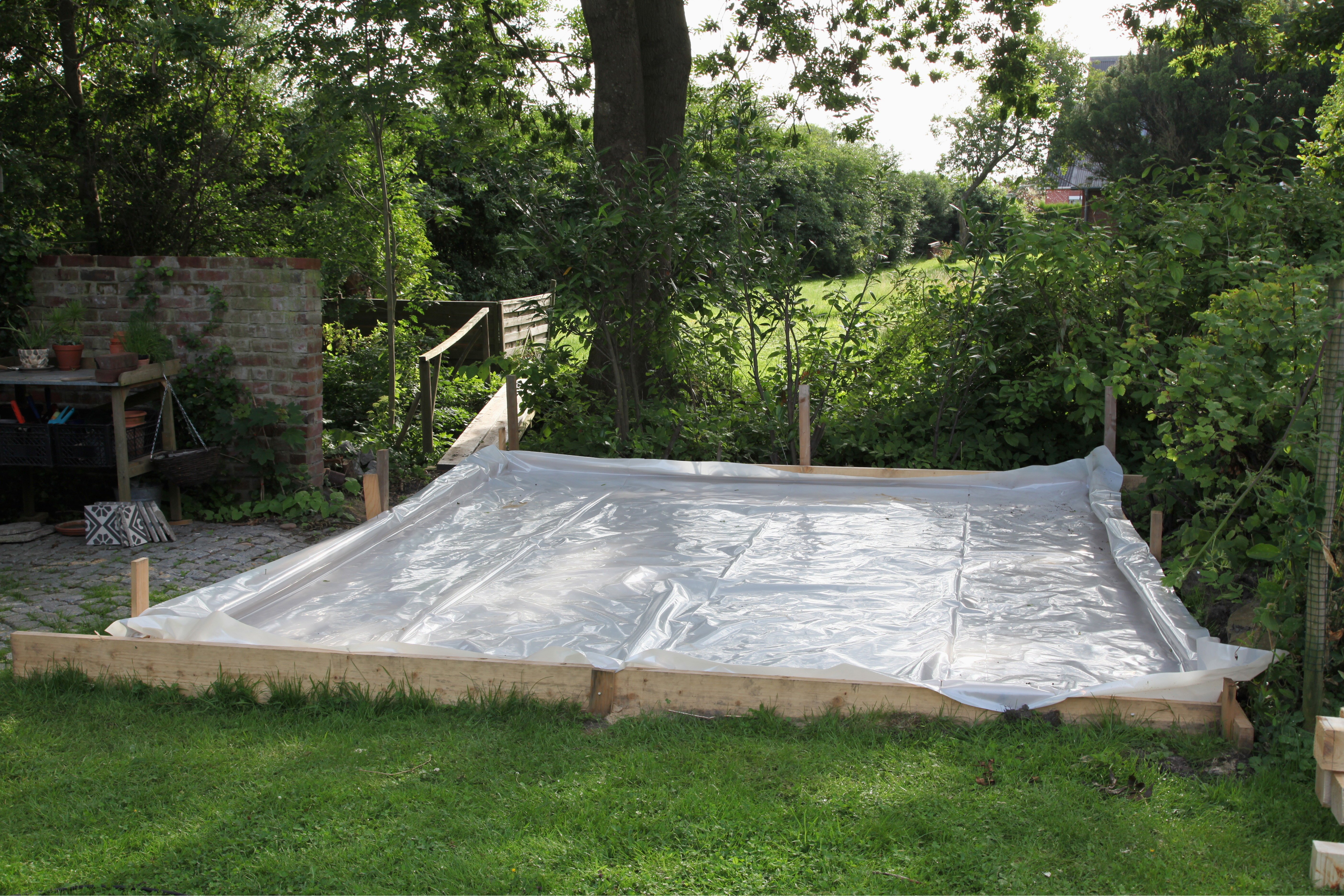 Egy kerti ház alapjának kijelölése fóliával.