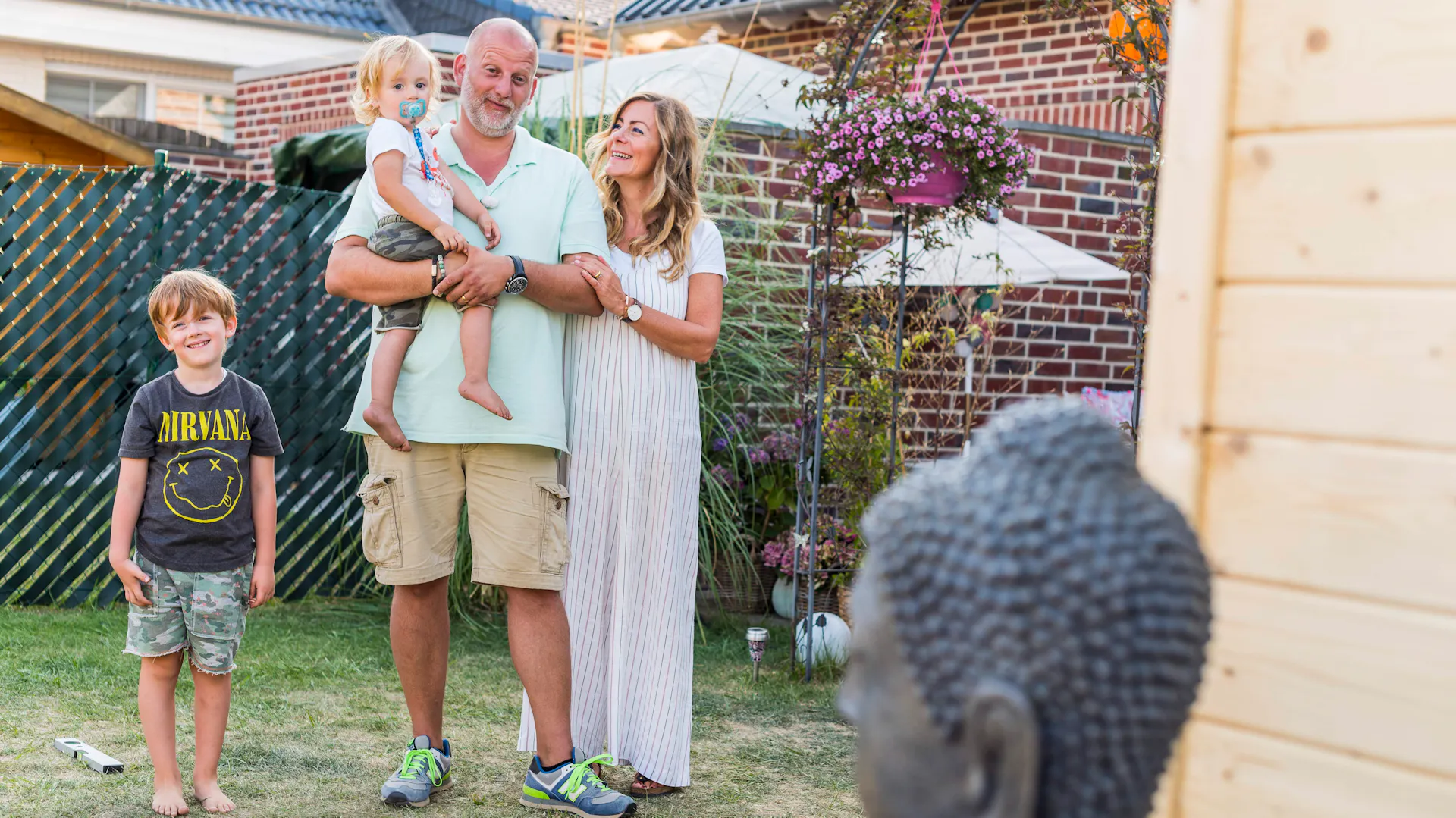 Familie mit Buddhakopf im Vordergrund.
