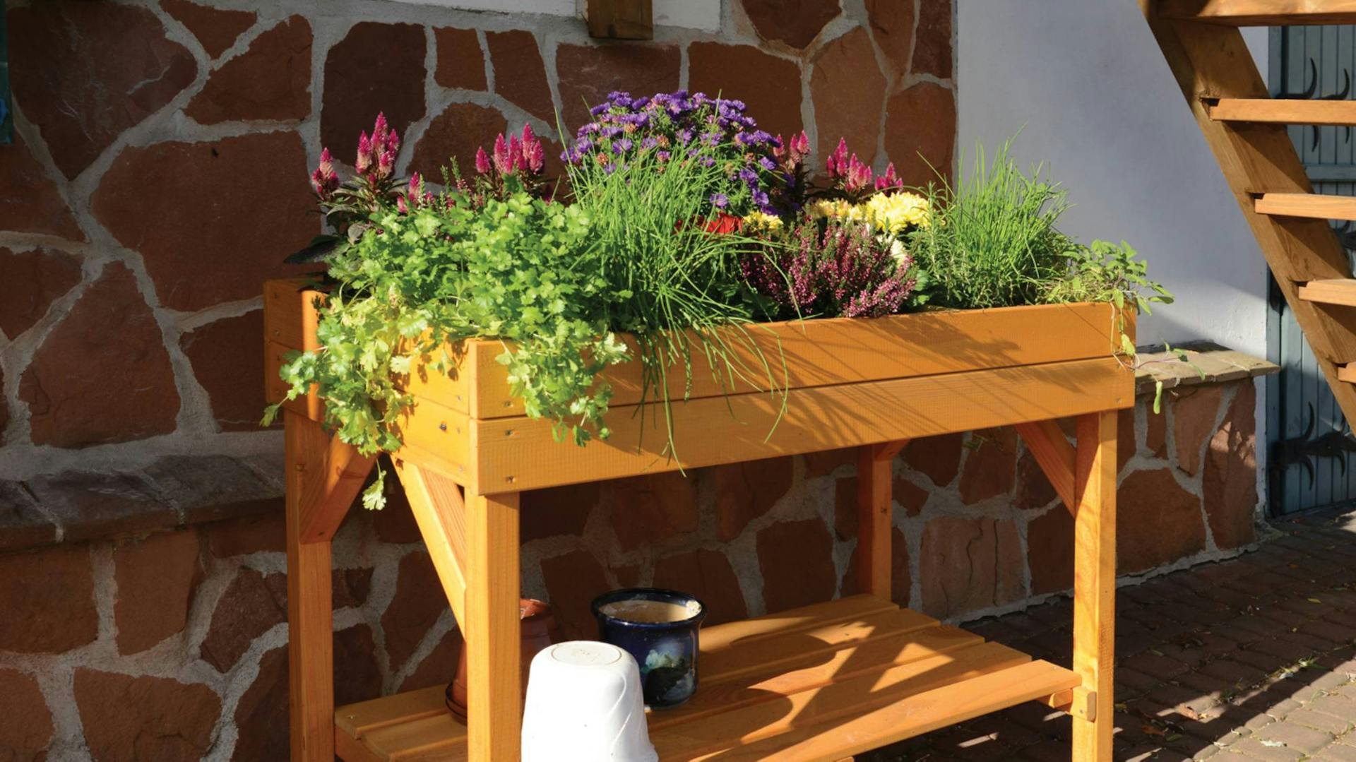Pflanztisch aus Holz an Hauswand