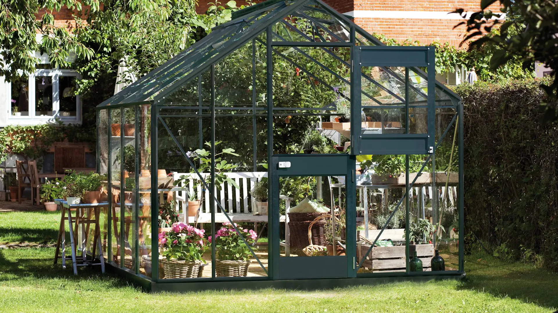Freistehendes Gewächshaus mit Pflanzen in Garten