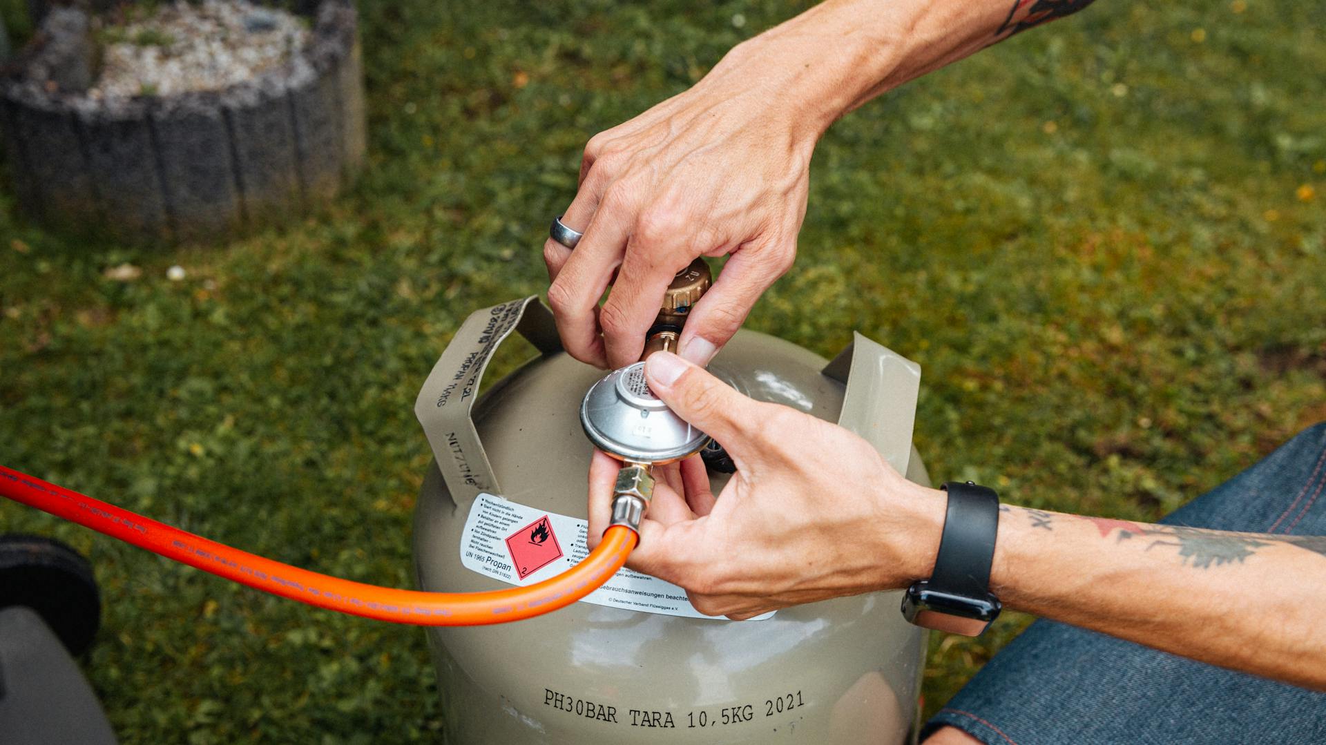 Mann schließt Gasflasche an