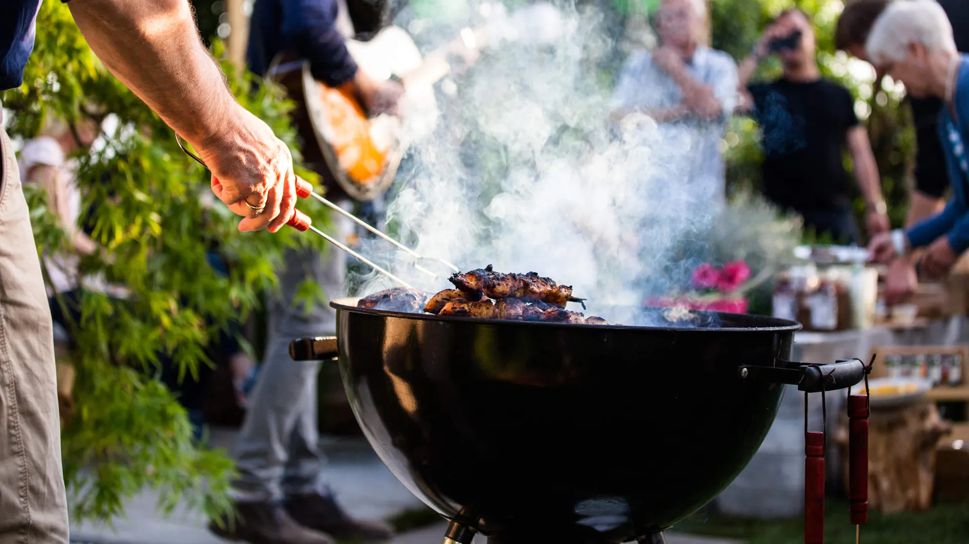 Un homme fait un barbecue pour sa famille.