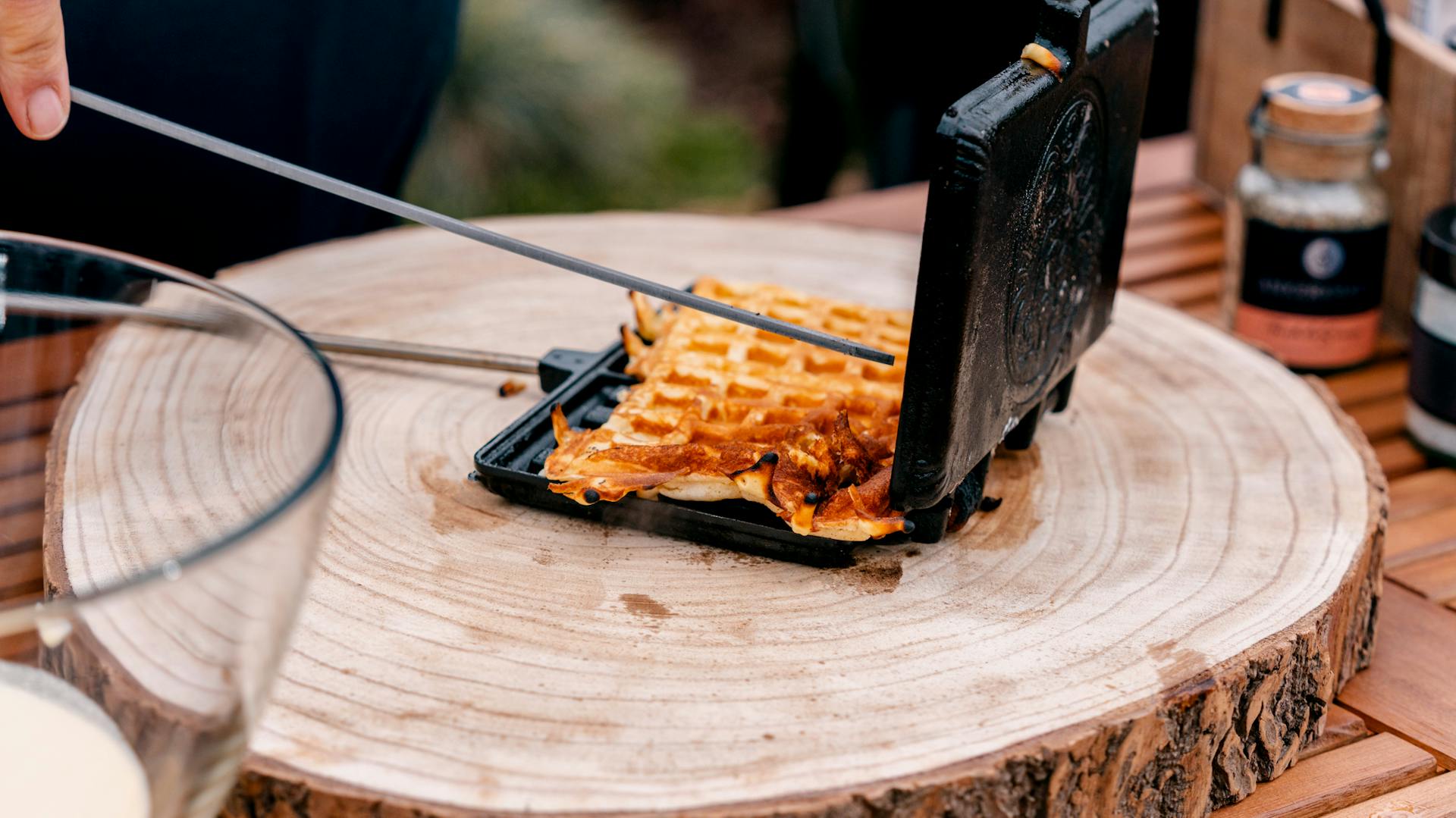 Person steht hinter einem Tisch mit Grill-Gadgets.