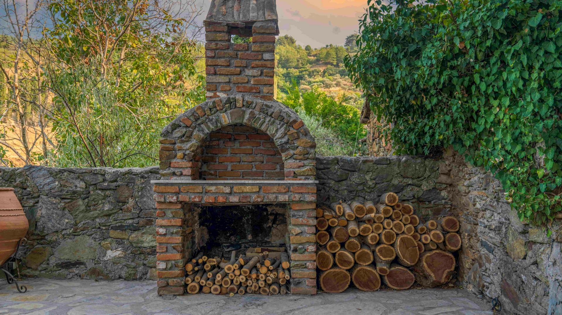 Gemauerter Grill im Garten an Natursteinwand