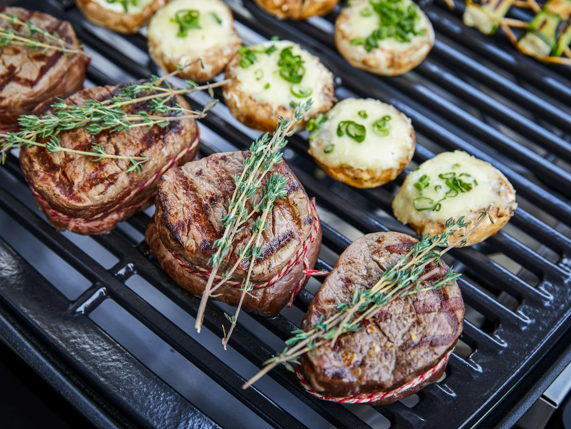 Perfekte Steaks mit Rosmarin auf Grillrost.