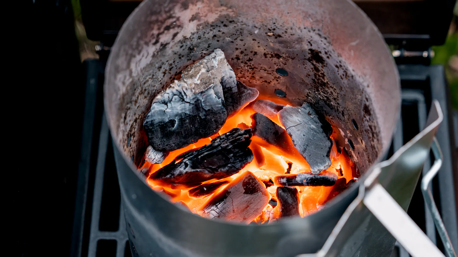 Anzündkamin mit glühender Kohle auf dem Grill