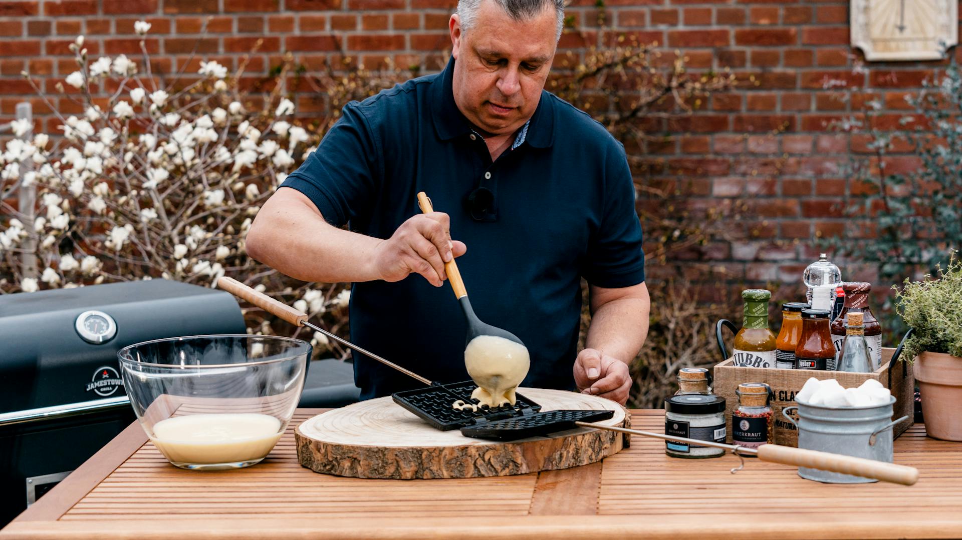 Teig für Waffeln auf Grill wird in Waffeleisen gefüllt