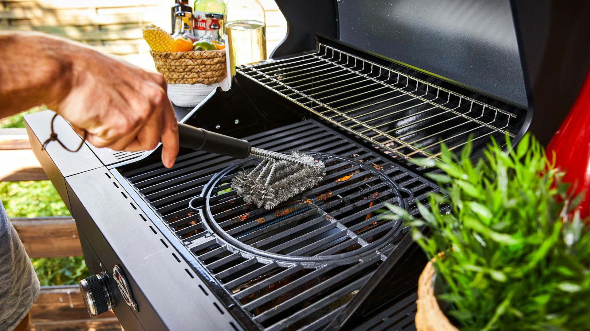 Jemand bürstet einen Grillrost ab.