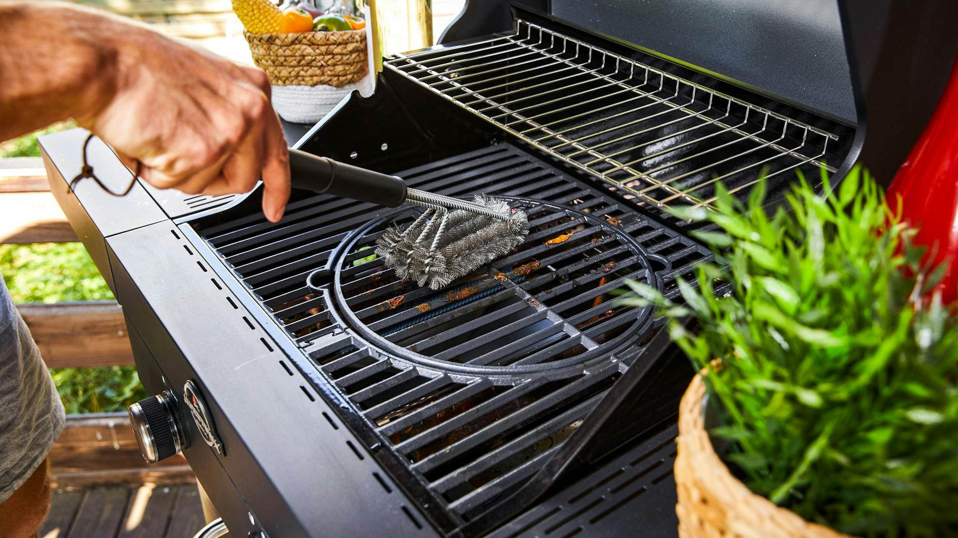 Jemand bürstet einen Grillrost ab.