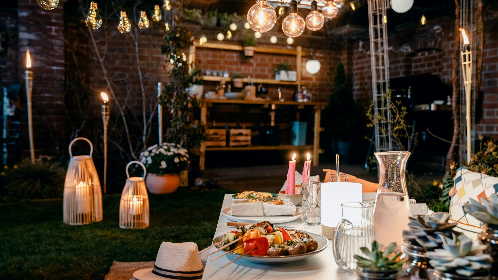 Grigliata con luci, sedute, grill e cucina esterna.