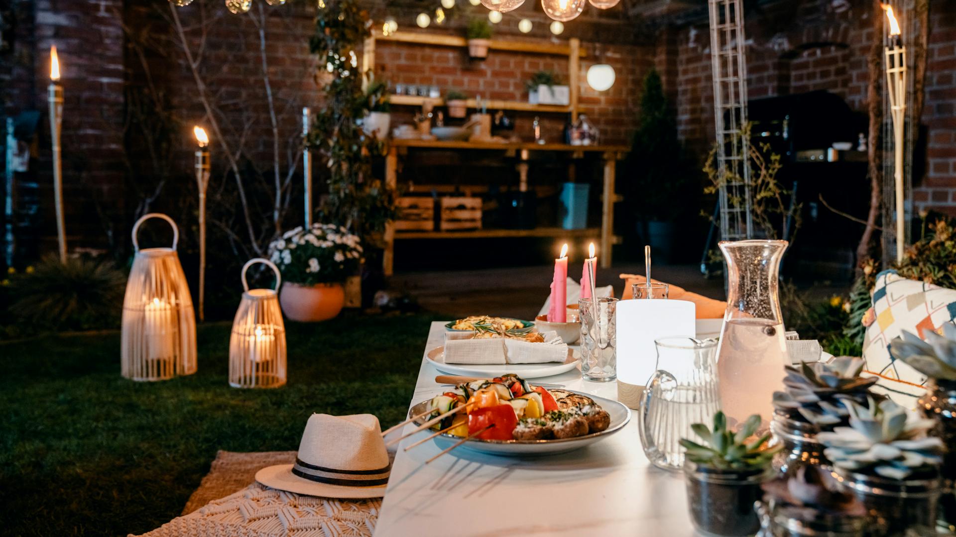 Beleuchteter Grillplatz in Garten mit Lichterketten, Fackeln, Kerzen und Laternen
