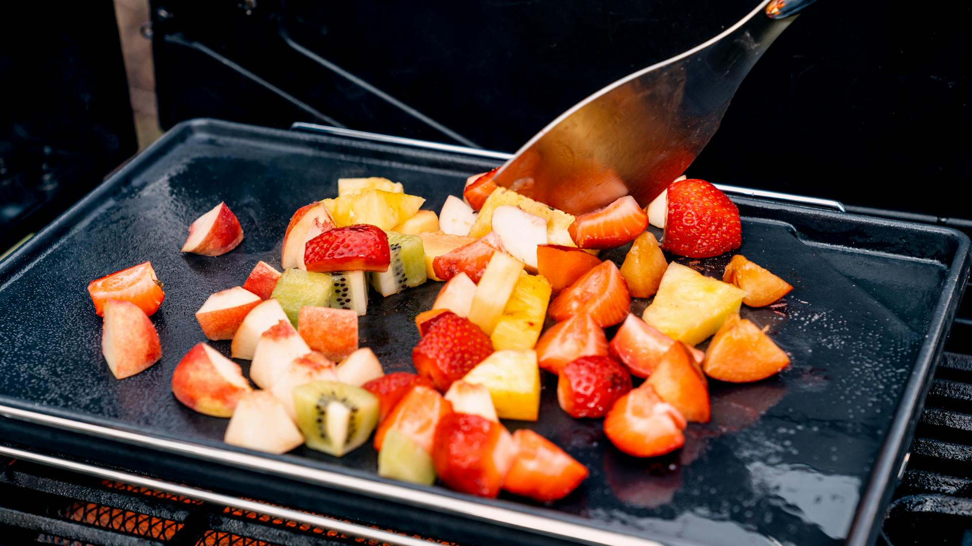 Obst auf Grill wird gewendet