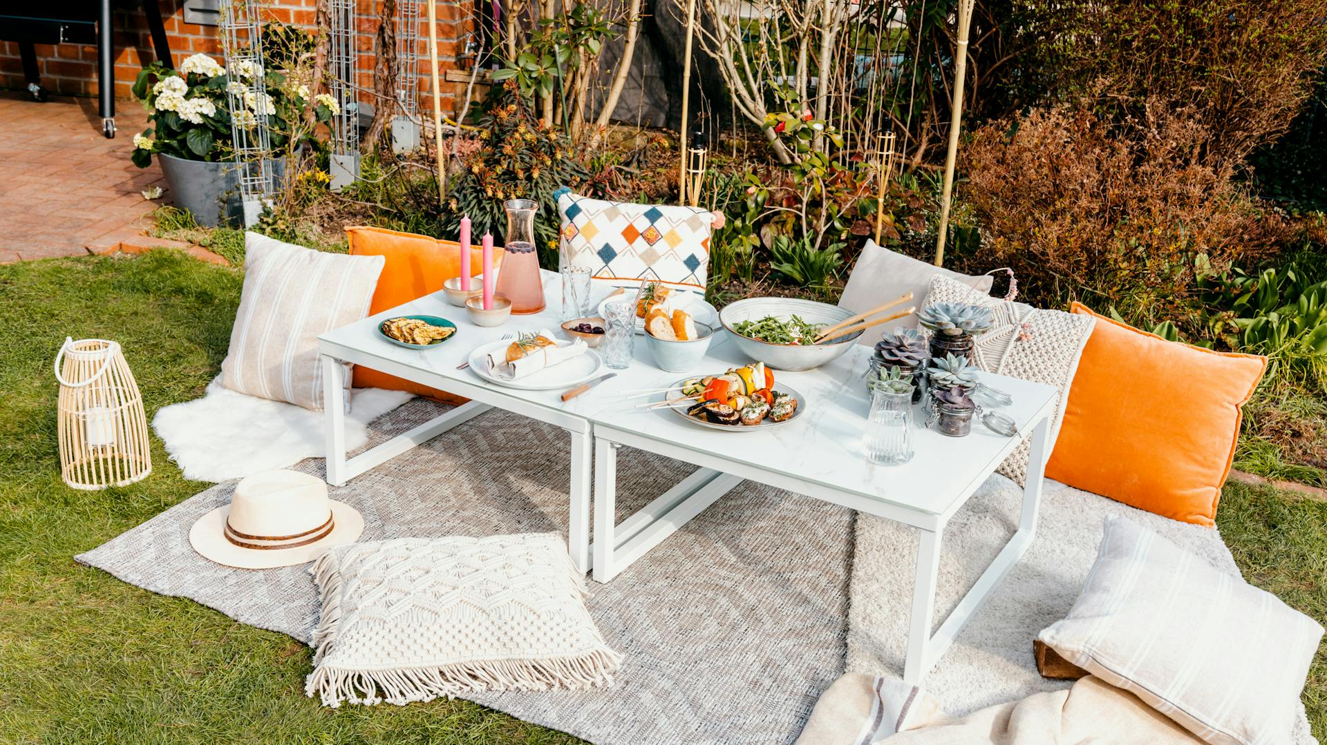 Sitzplatz mit gedecktem hellblauem Tisch und Sitzkissen in Garten