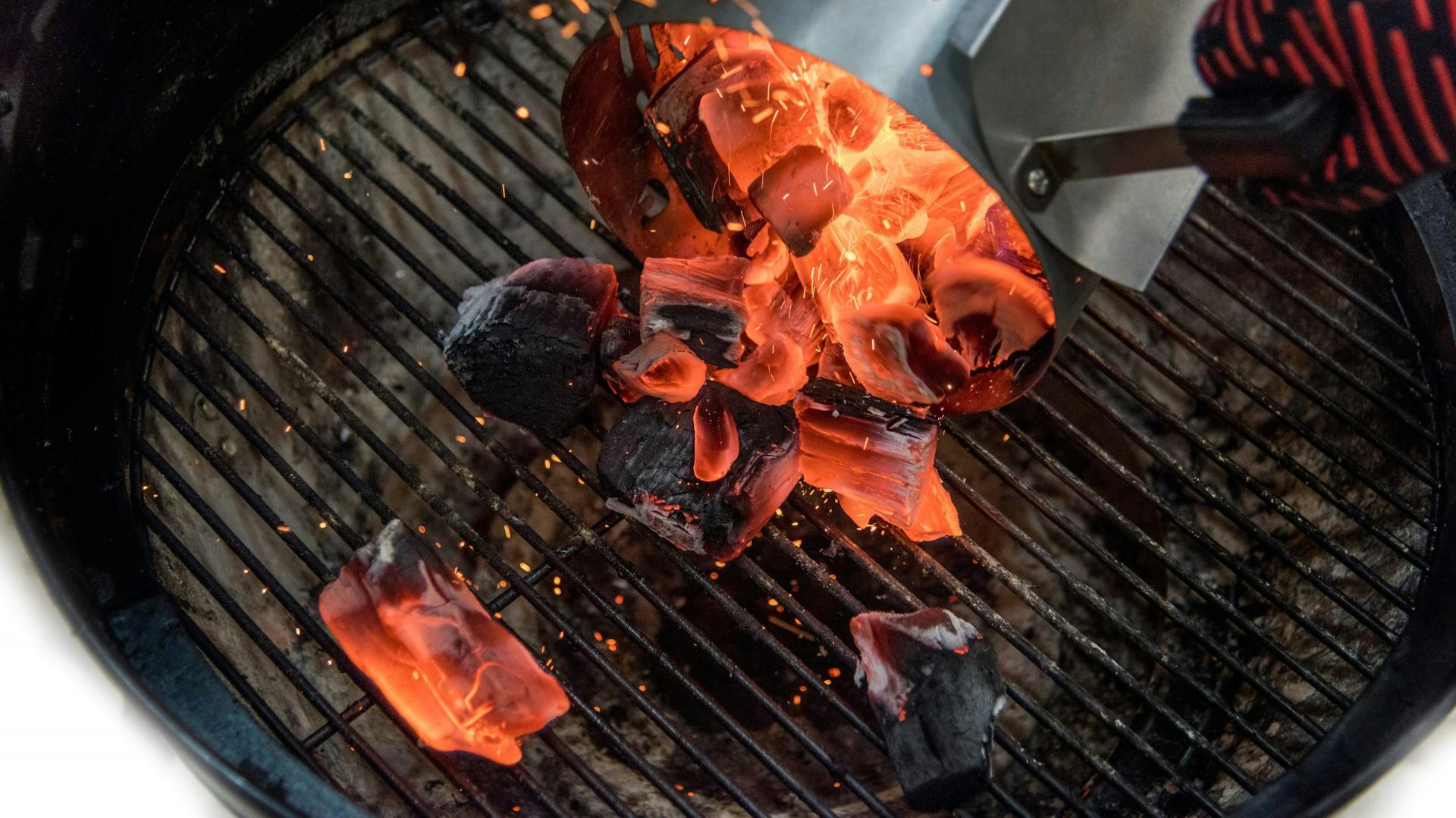 Mann bereitet Holzkohlegrill vor.