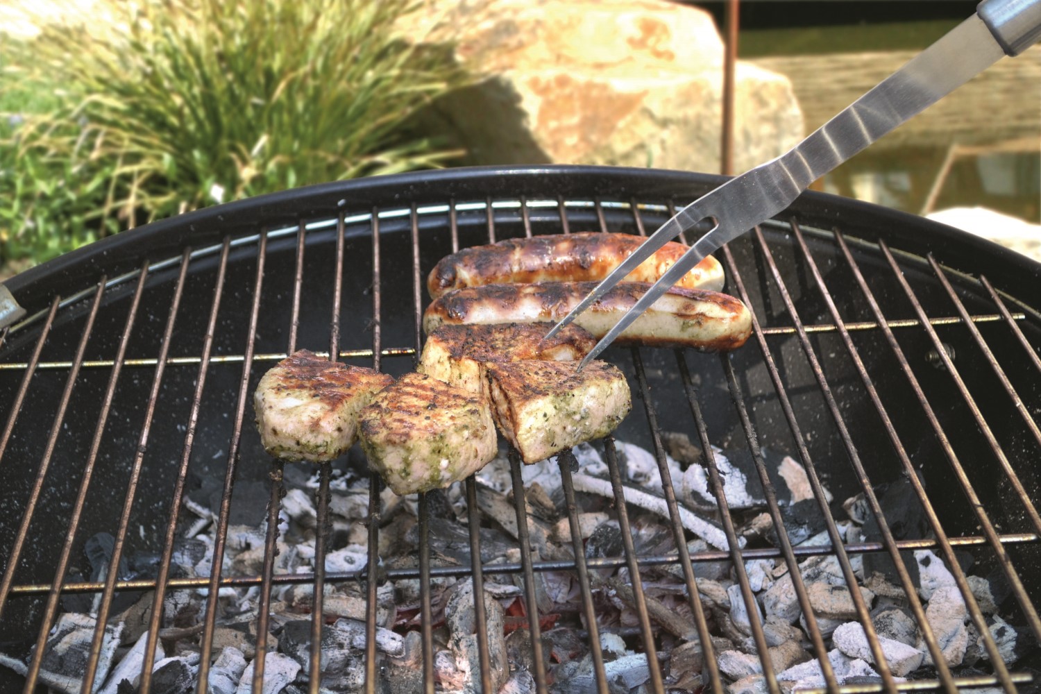 Gli alimenti da grigliare poggiano su un grill a carbonella.