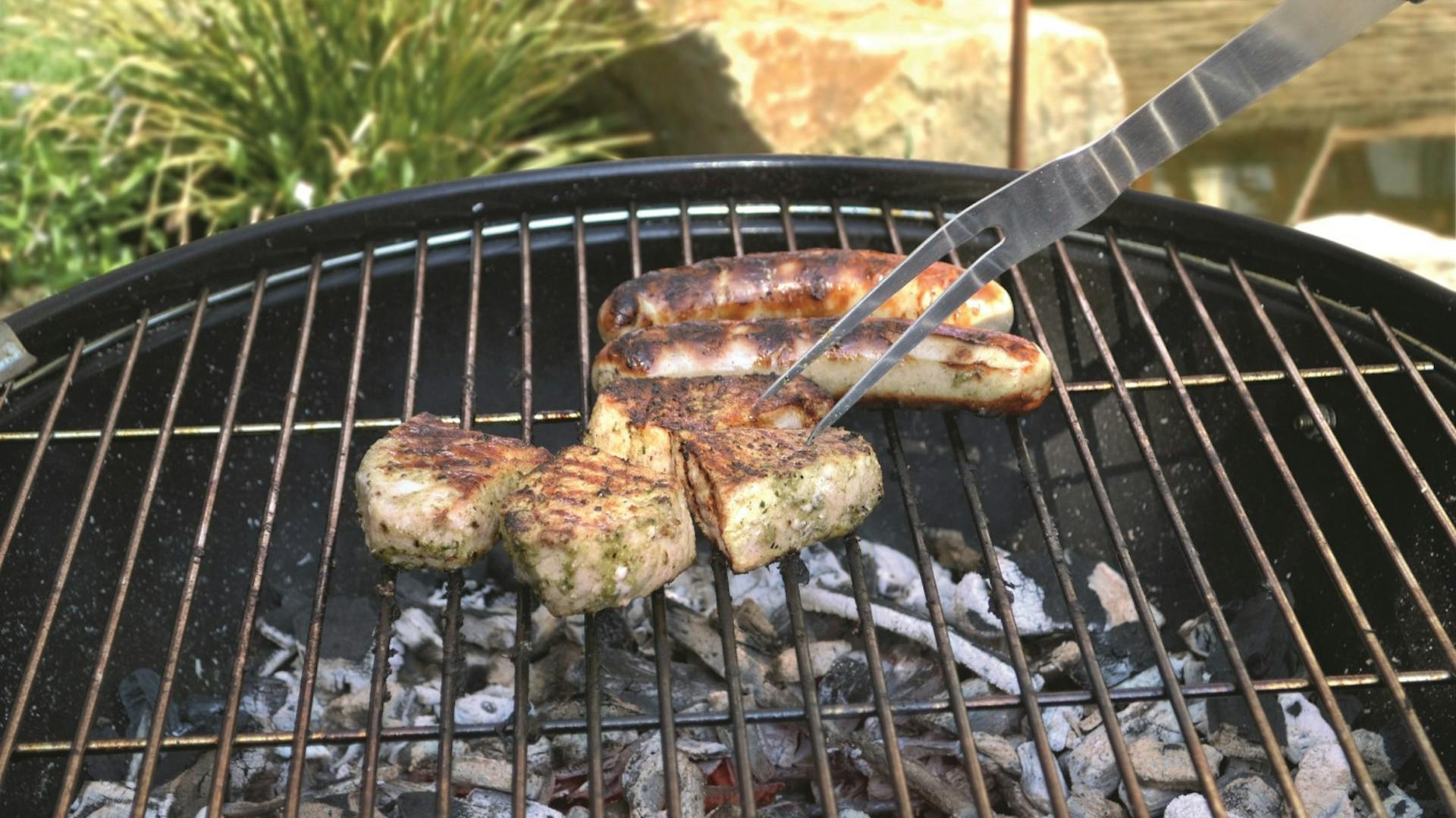 Gli alimenti da grigliare poggiano su un grill a carbonella.
