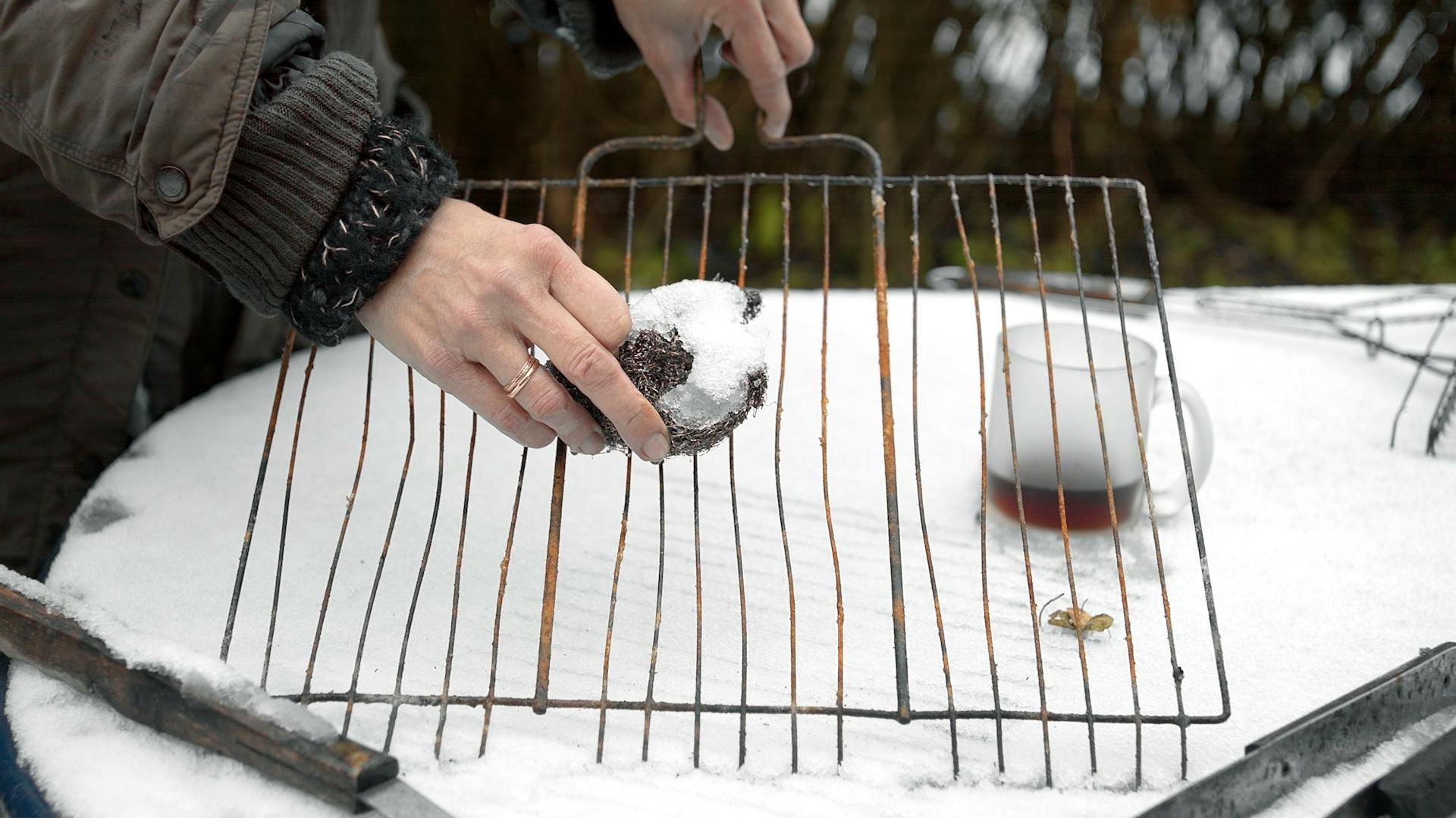 Grillrost wird nach dem Wintergrillen gereinigt.