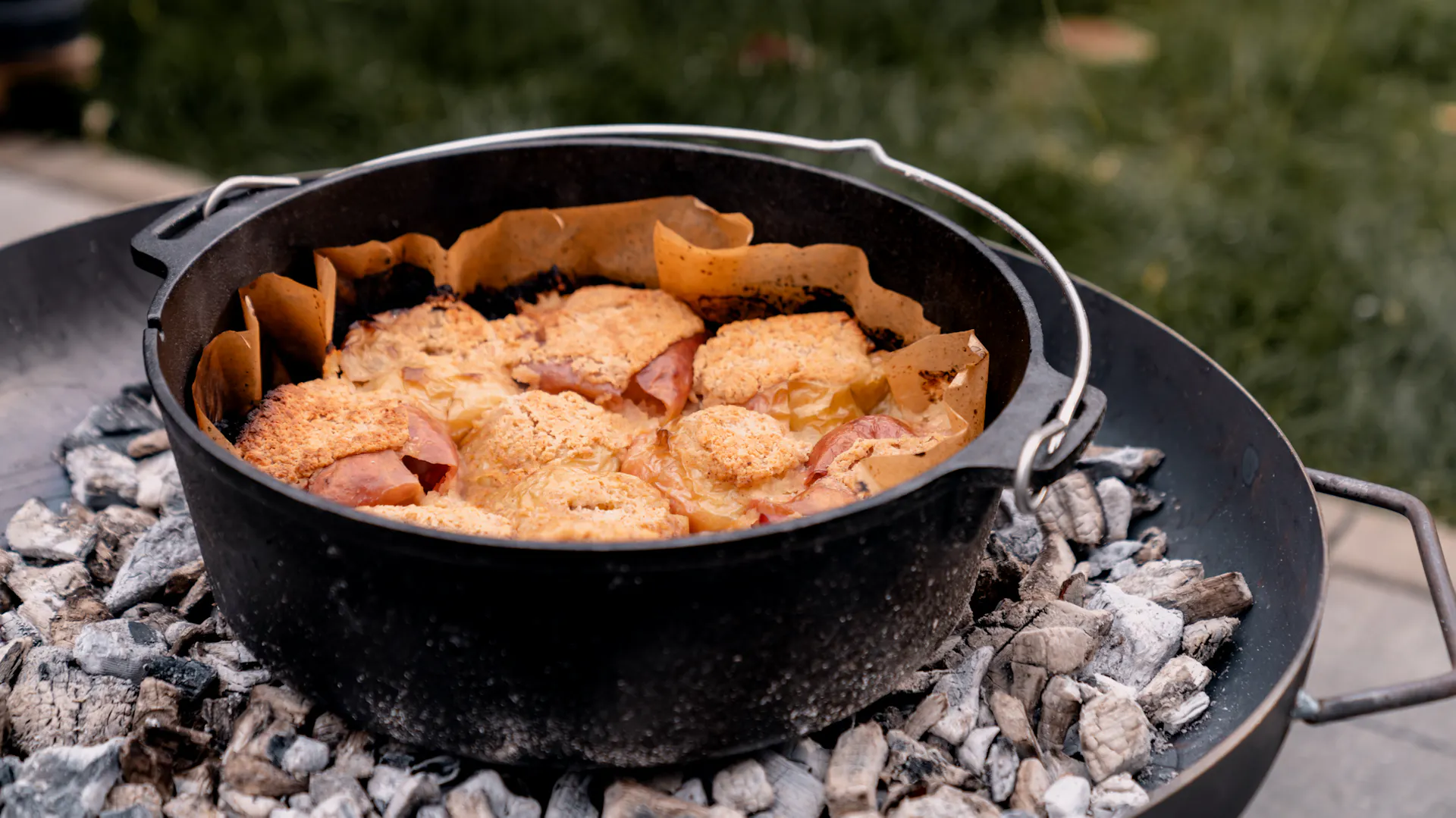 Nyitott holland sütő forró parázson, benne lédús sült almák