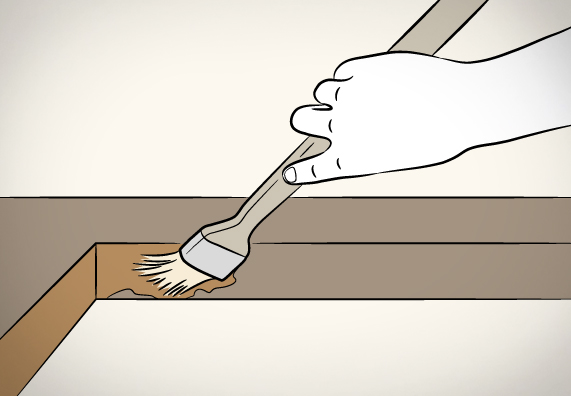 Egy személy ecsettel impregnál egy asztallapot