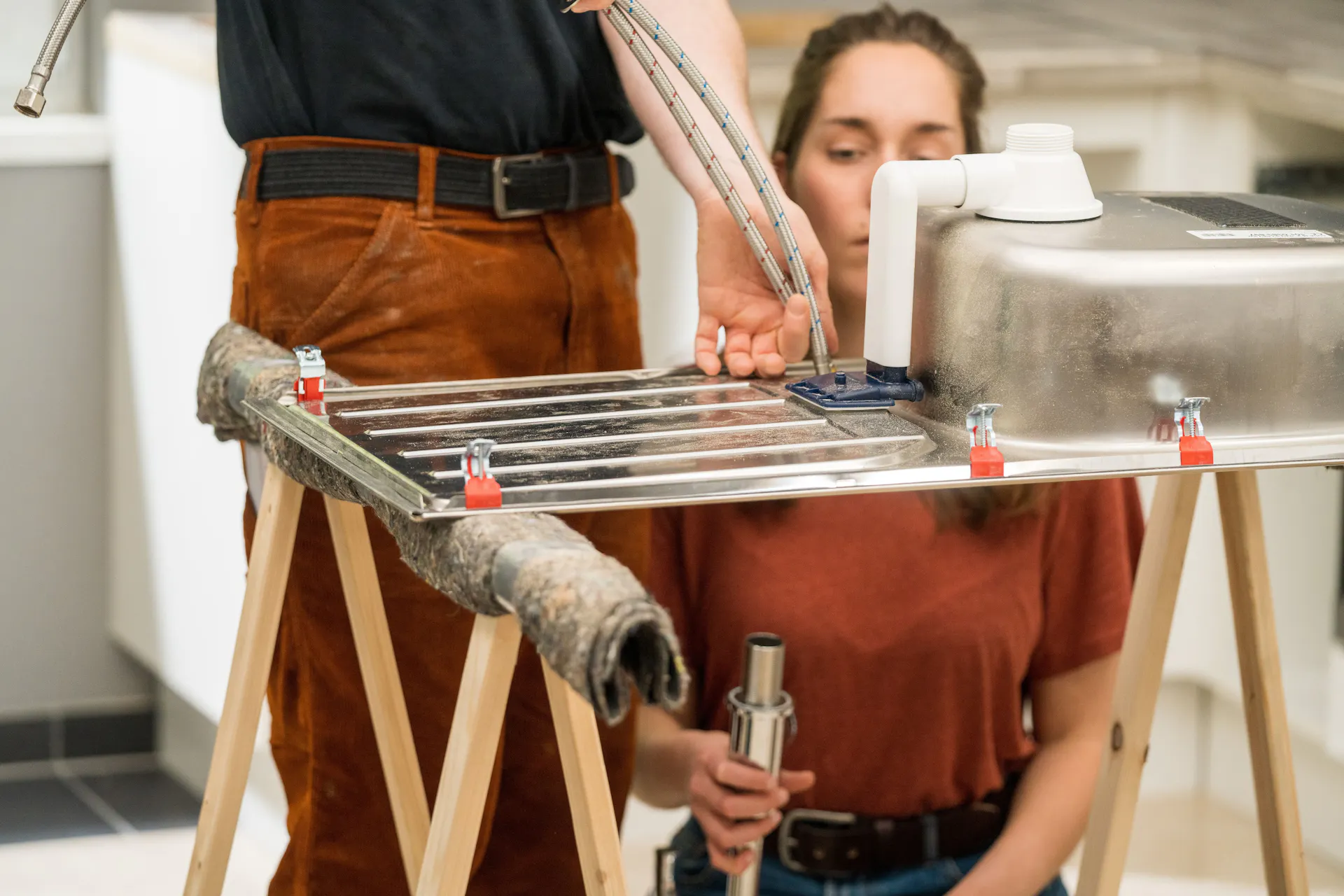 A barkácsolók összecsavarozzák a mosogatót és a csaptelepet.