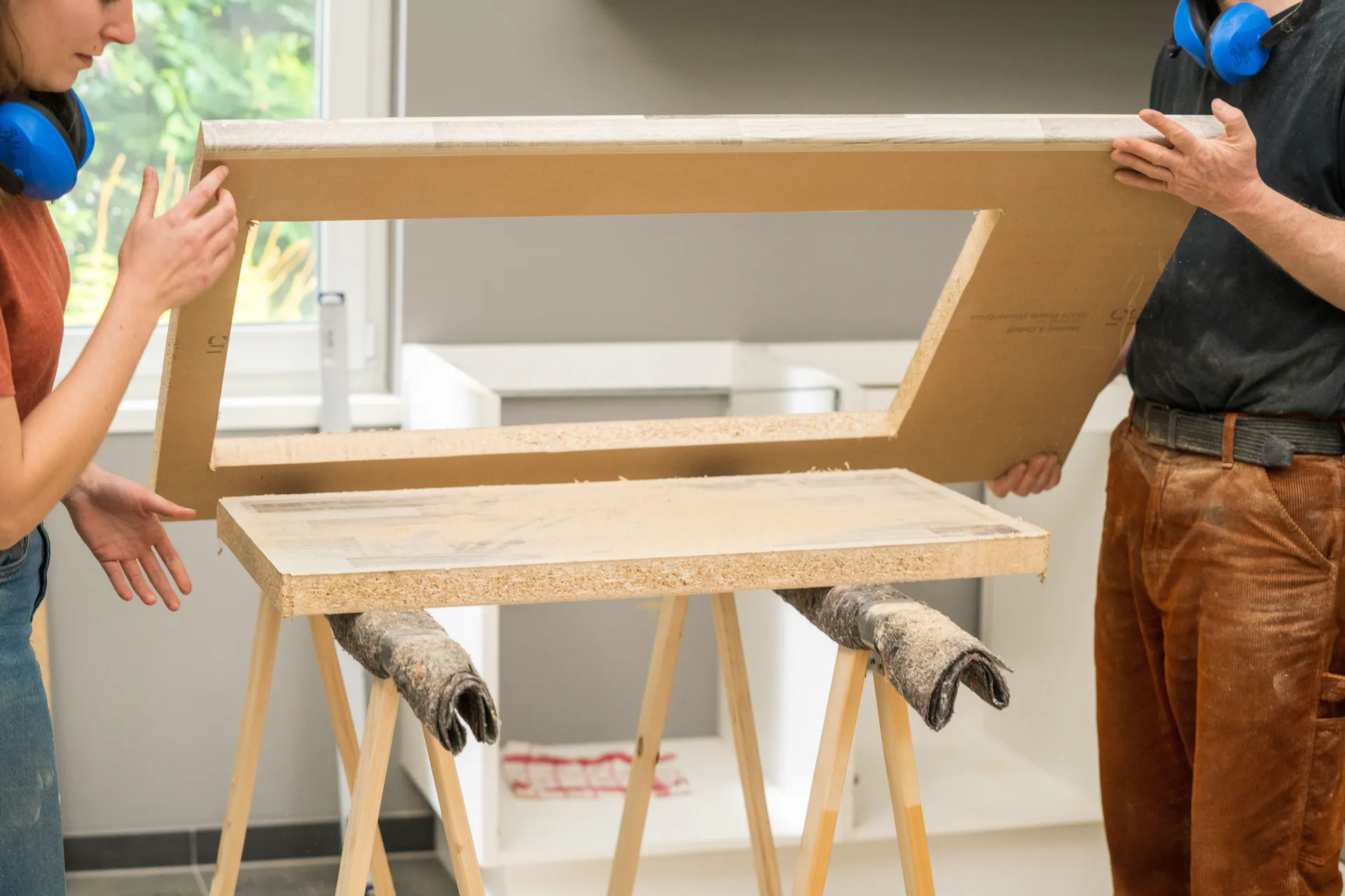 A barkácsolók megemelik a mosogató számára kivágott munkalapot.