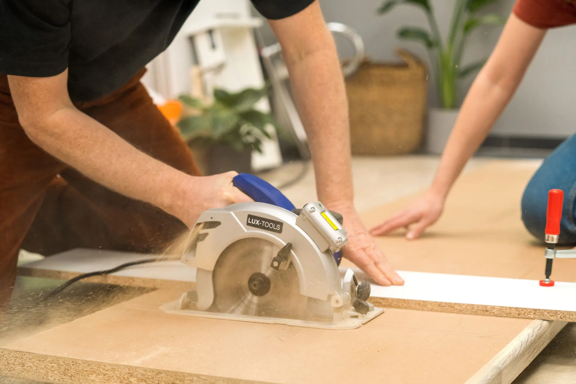 Barkácsolók méretre vágják a lapokat.