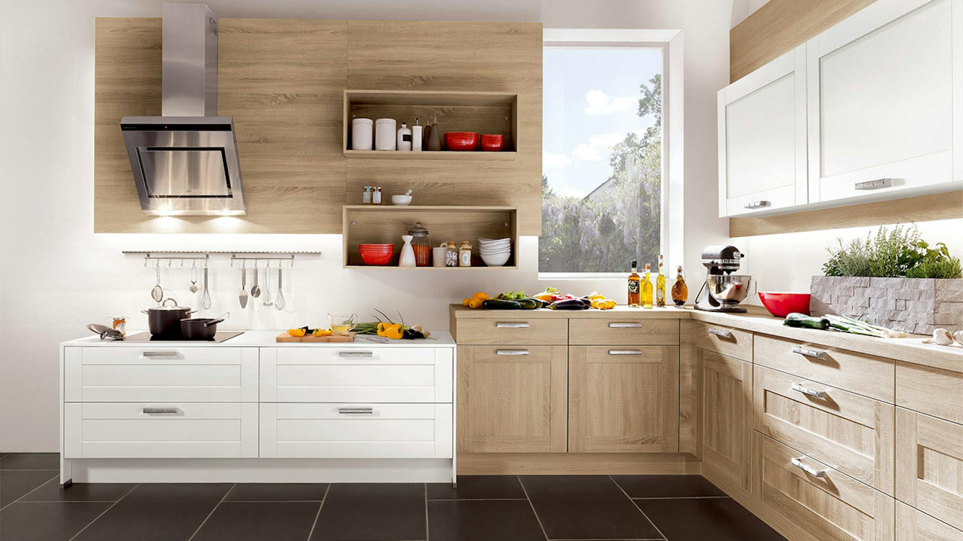 Eine hell eingerichtete Küche mit unterschiedlich hohen Arbeitsbereichen.