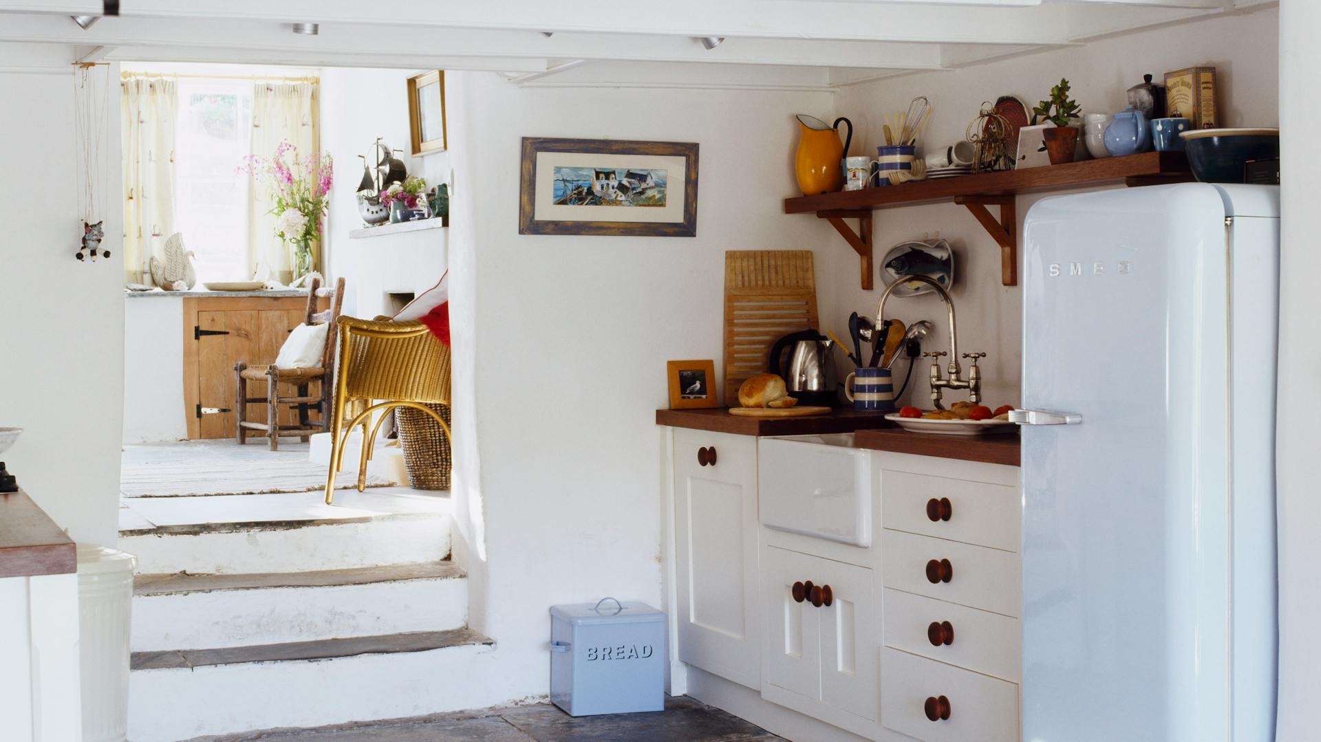 Eine weiße Landhausküche mit einem großen Retro-Kühlschrank.