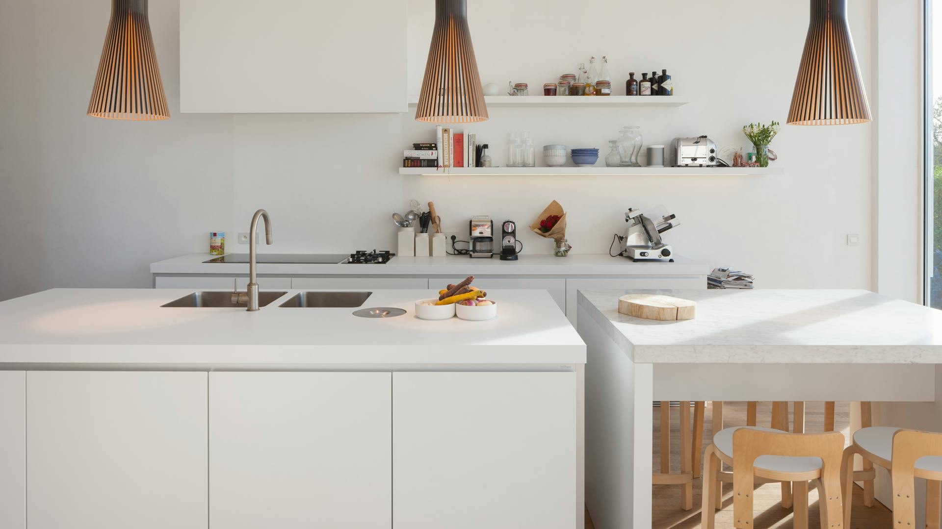 Kleine weiße Küche mit Kücheninsel.