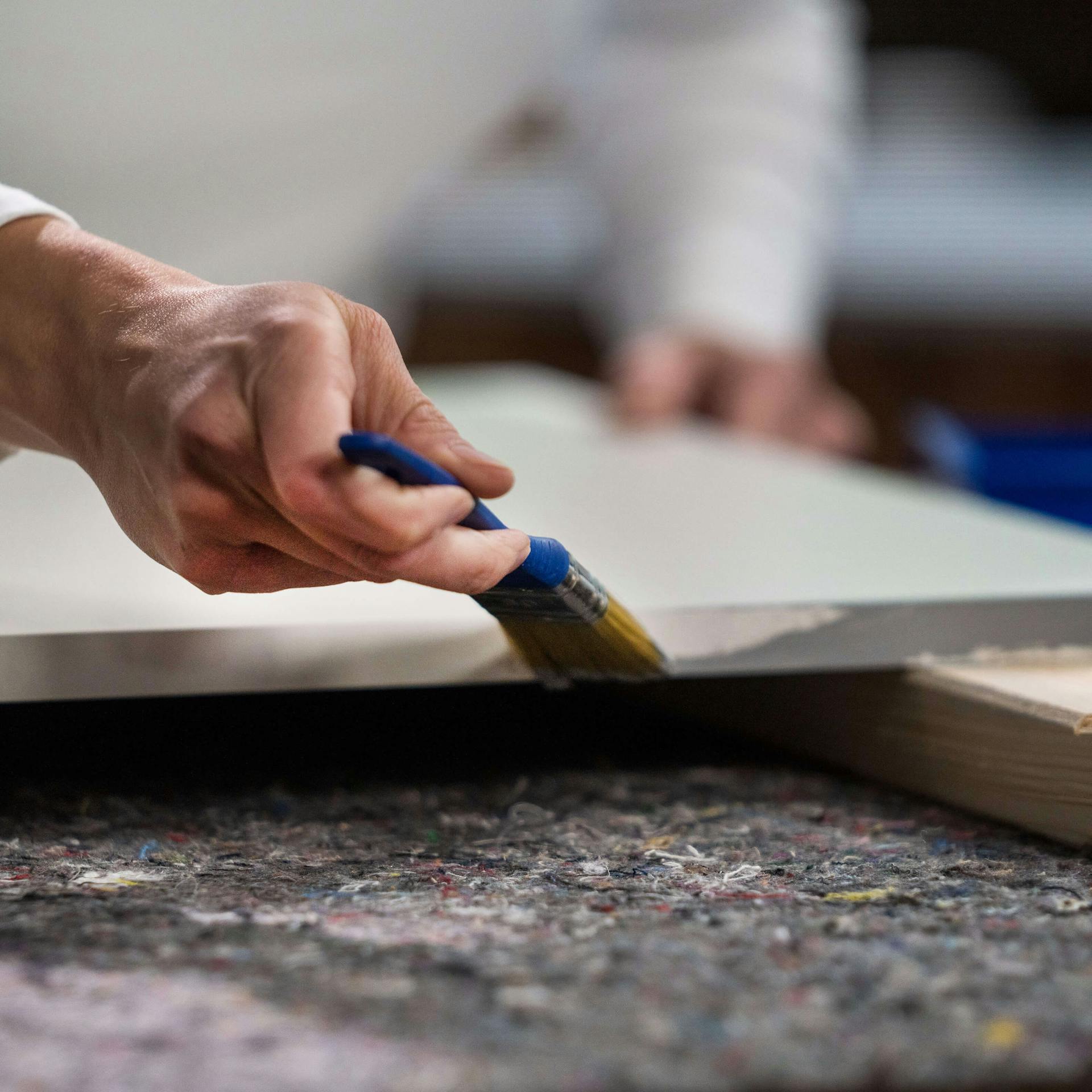 Egy konyhai front oldalainak lakkozása szürke festékkel.