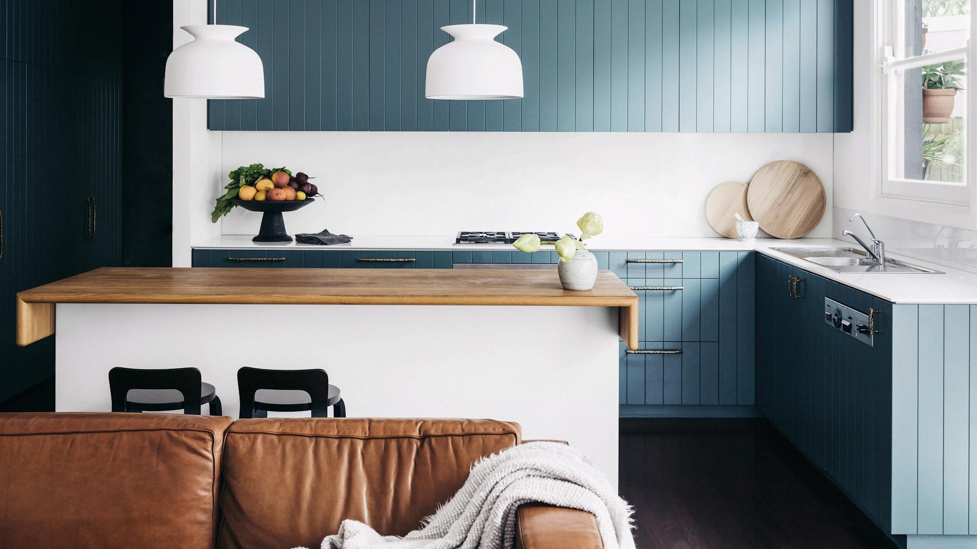 Weiße Kücheninsel mit Arbeitsplatte aus Holz in blau-weißer Wohnküche