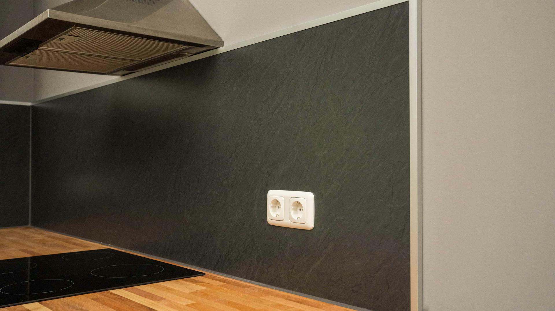 Eine graue Küchenrückwand mit silbernen Abschlussleisten