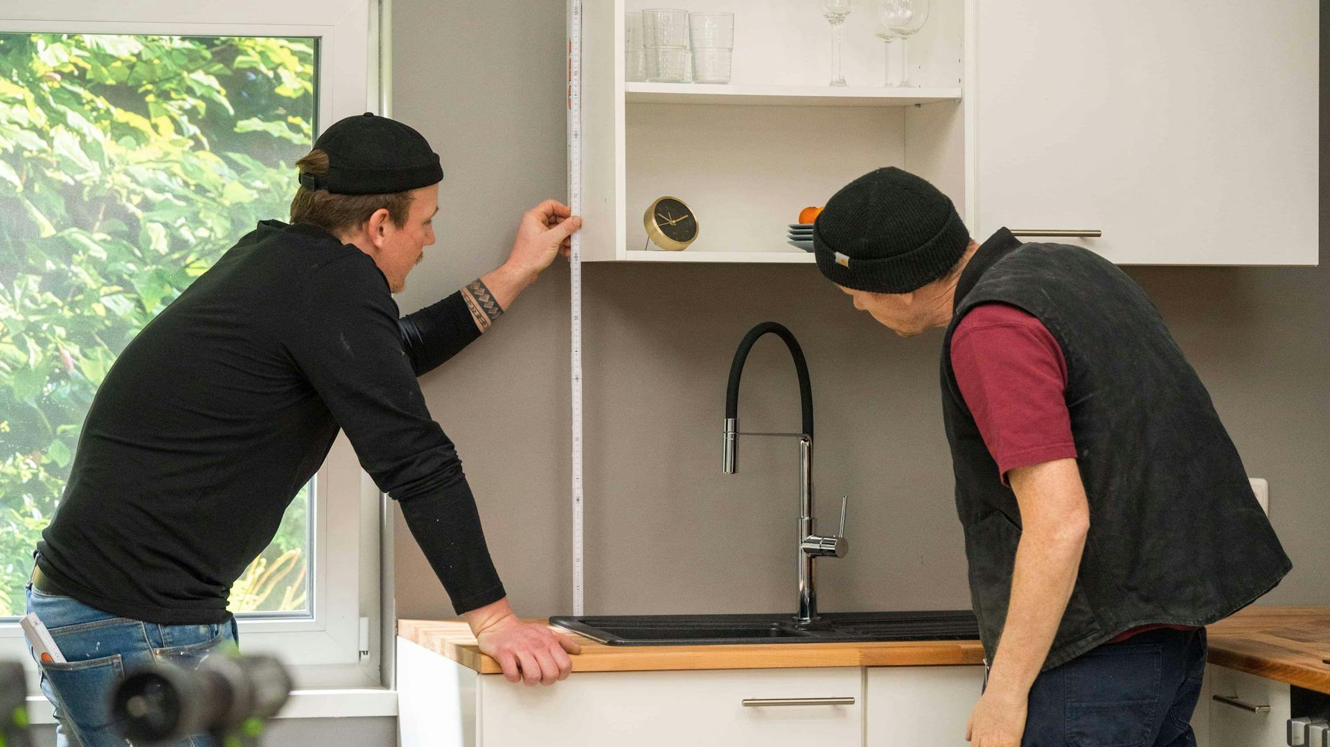 Zwei Personen nehmen Maß für die Küchenrückwand