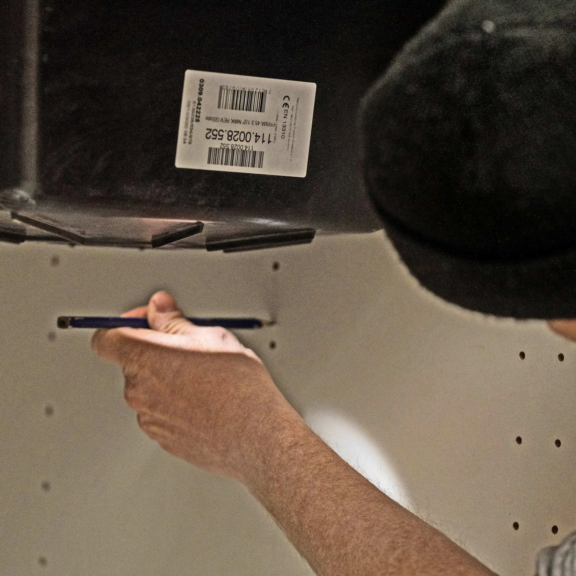 Heimwerker markiert die Platte mit einem Bleistift.