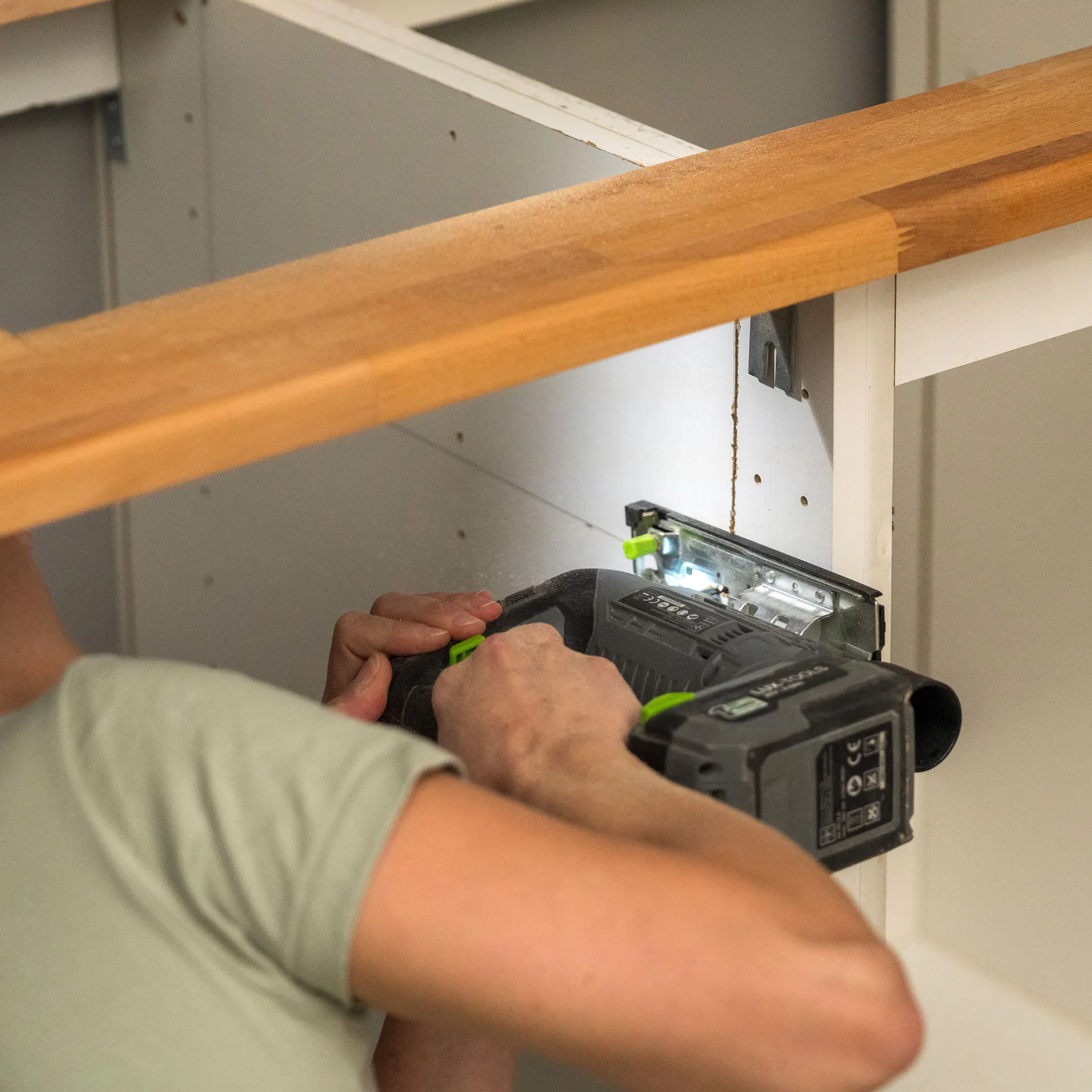 Heimwerker sägt den Unterschrank der Spüle zu.