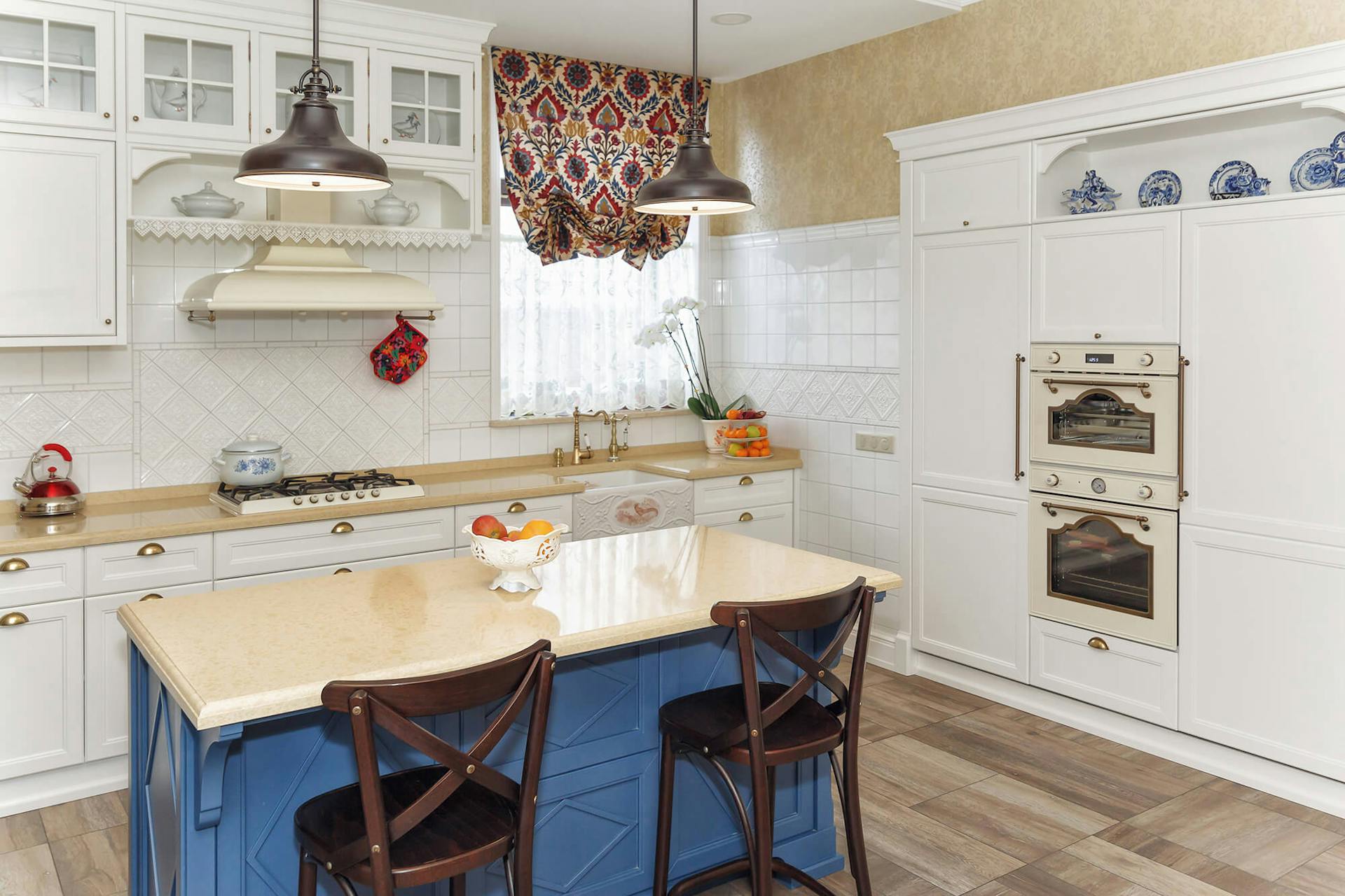 Cucina di campagna con allegre lampade sospese sull’isola della cucina