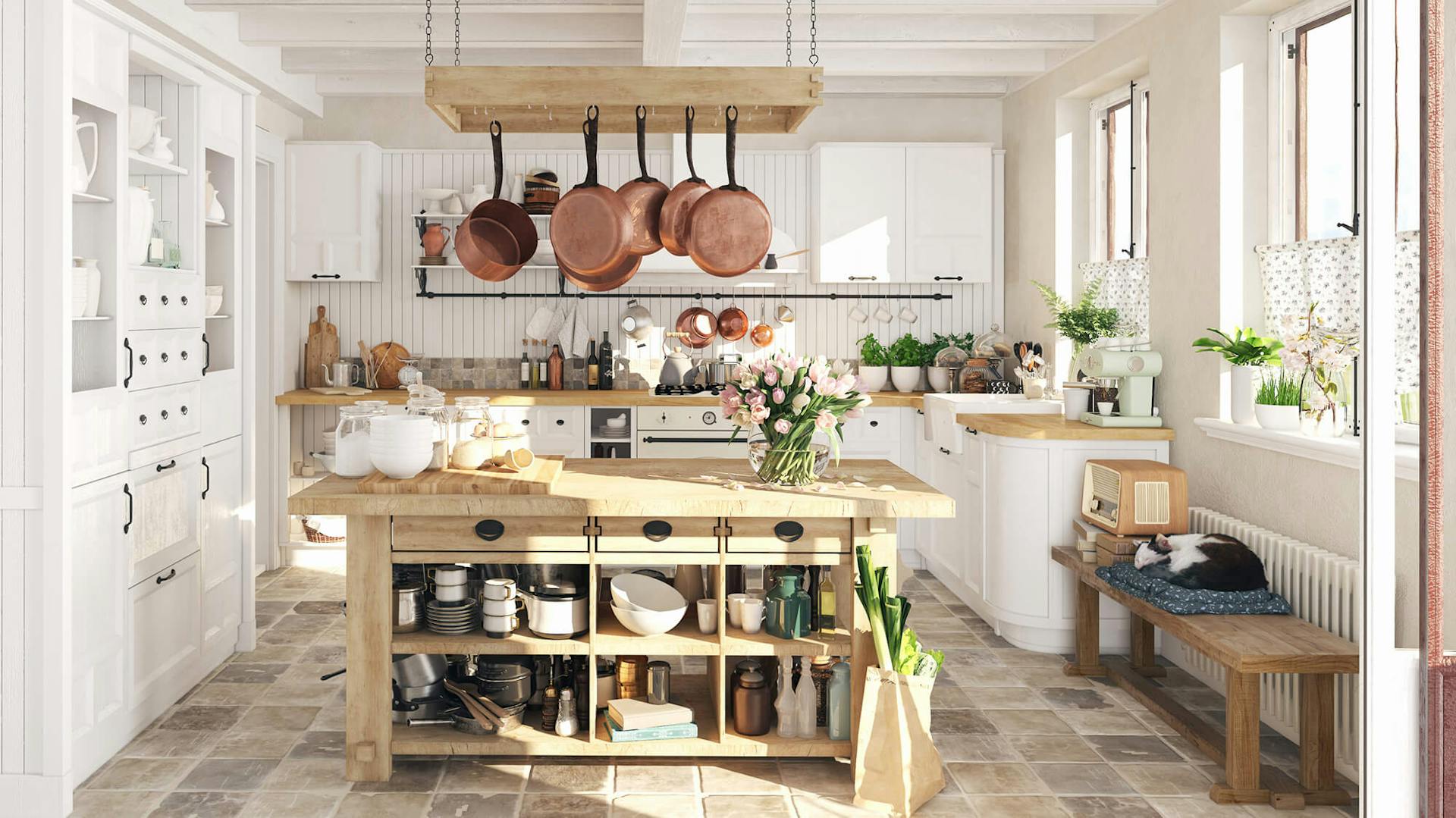 Weiße Landhausküche in U-Form. In der Mitte steht eine Kücheninsel aus Holz.