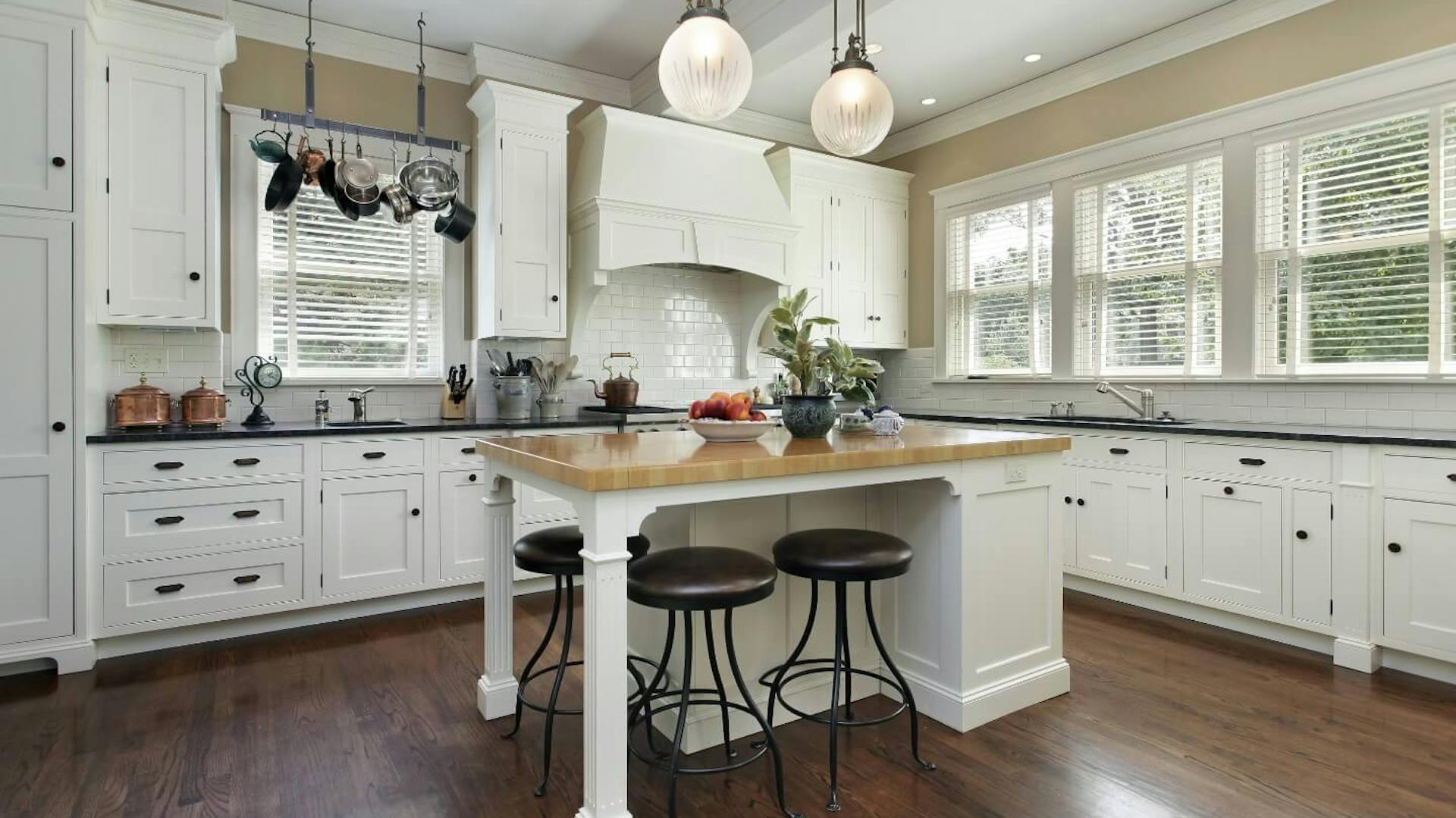 Weiße Landhausküche in L-Form mit Kücheninsel.