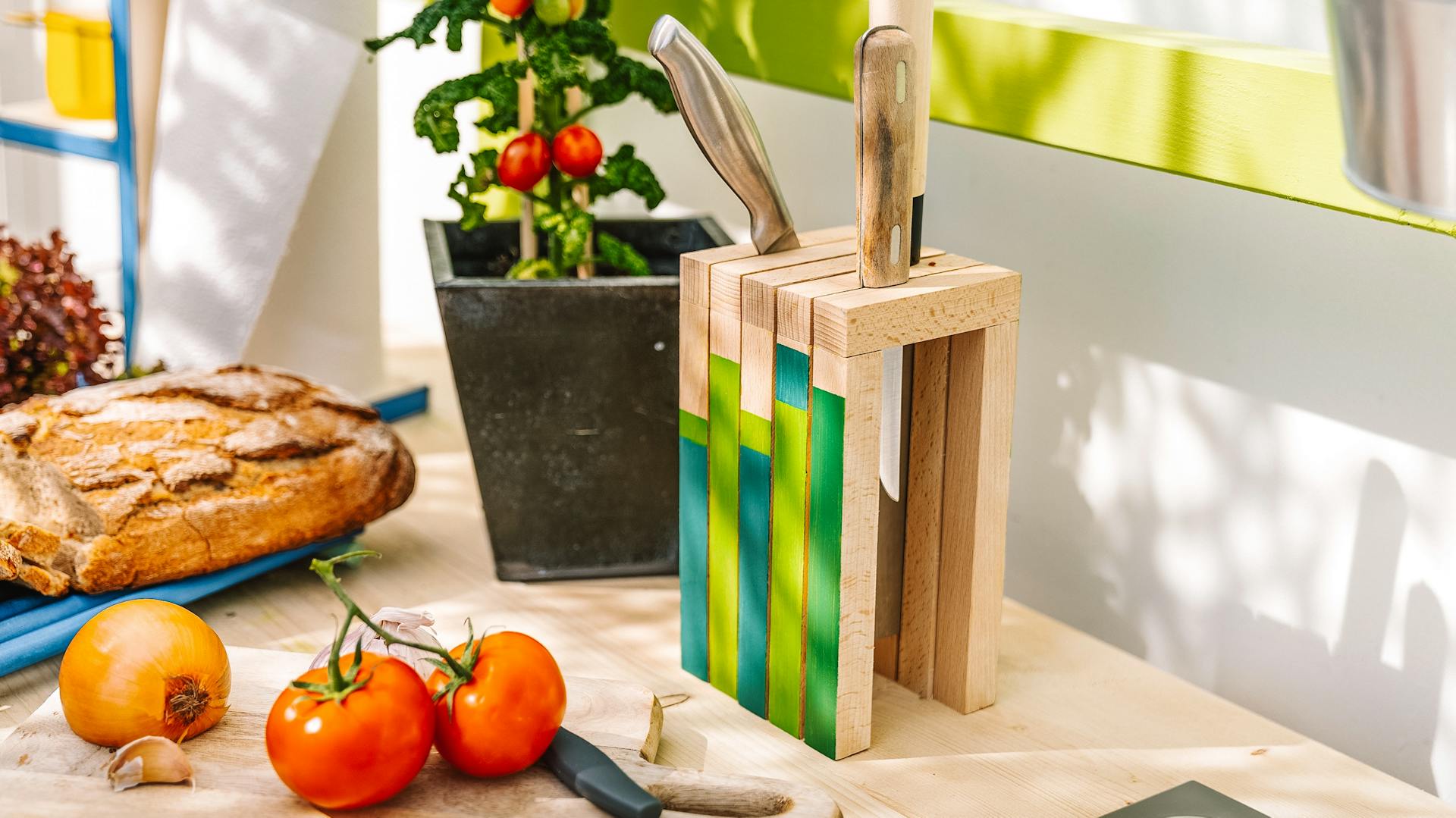 Messerblock steht auf Arbeitsplatte und daneben liegt ein Schneidebrett mit Tomaten und Zwiebeln