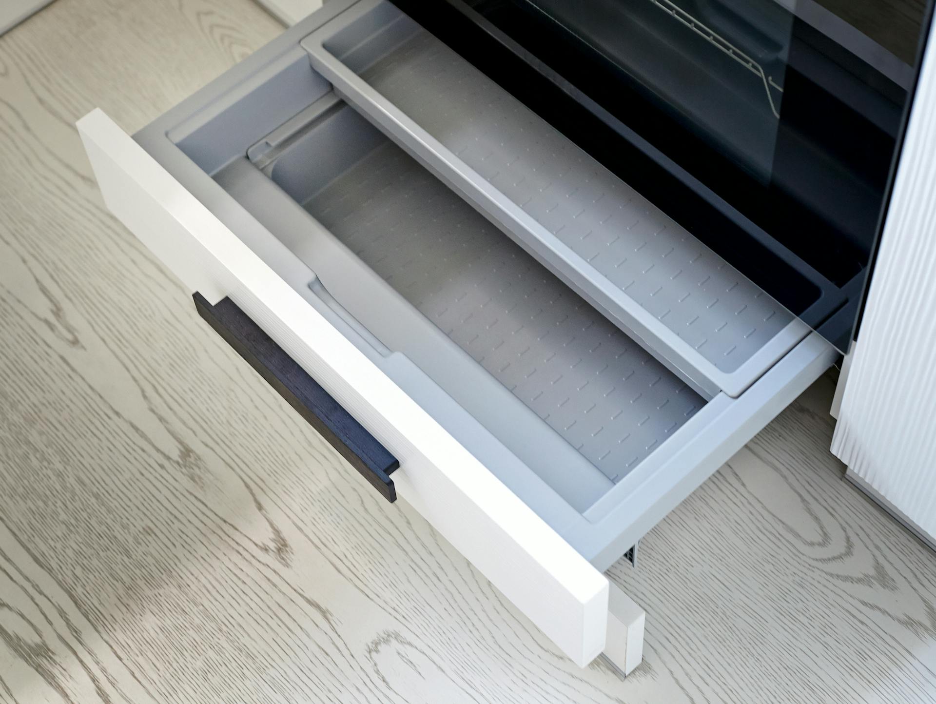 Ein Sockelschublade befindet sich unter einem Backofen.