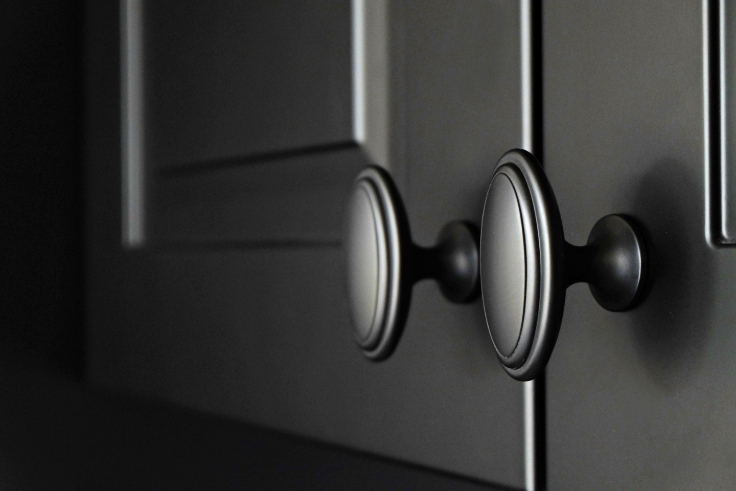 Mattschwarze Küchentüren mit schwarzen Griffen.