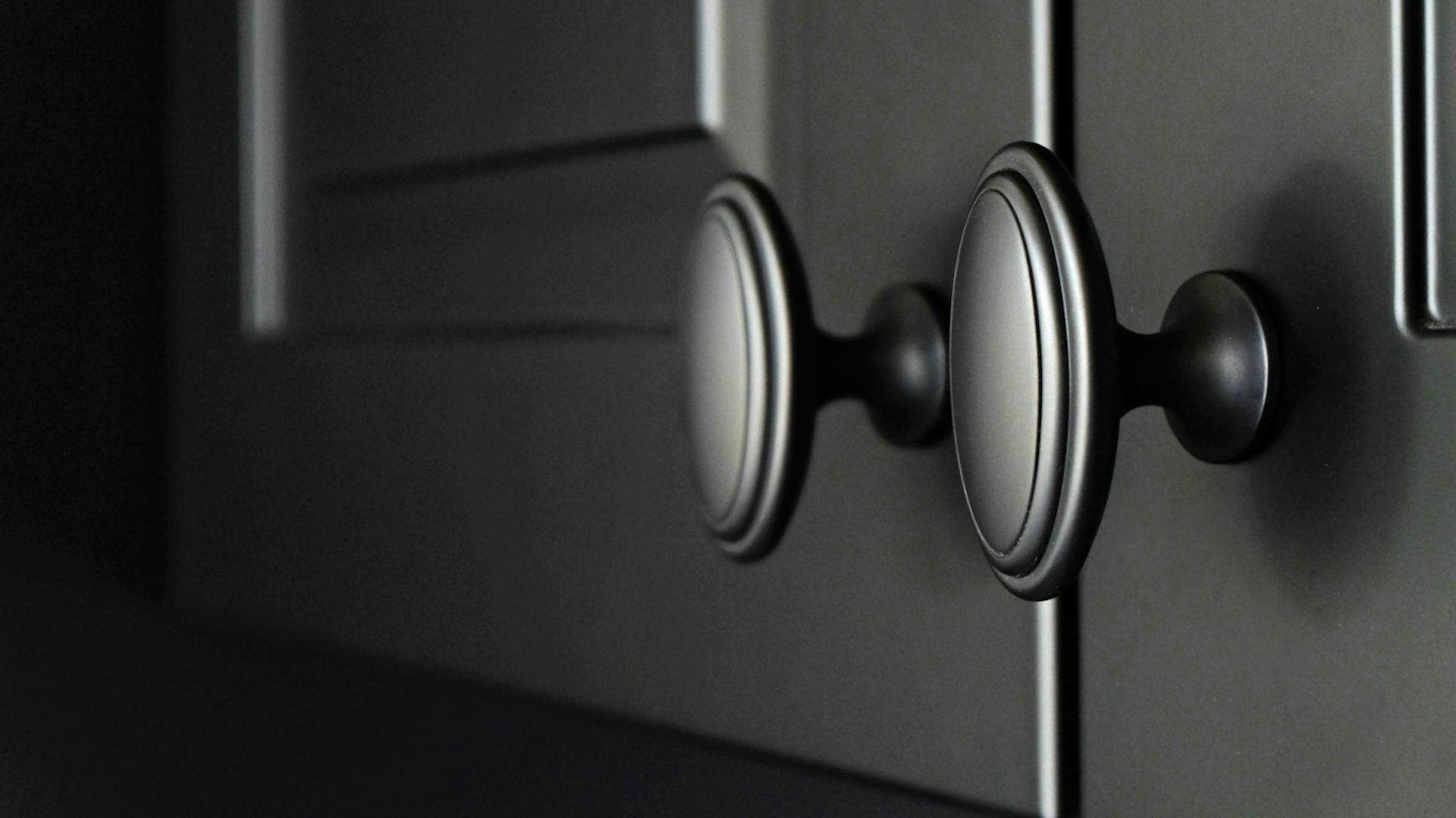 Mattschwarze Küchentüren mit schwarzen Griffen.