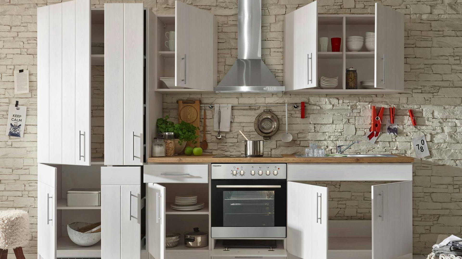 Kleine Küche mit platzsparenden Elementen und geöffneten Schranktüren