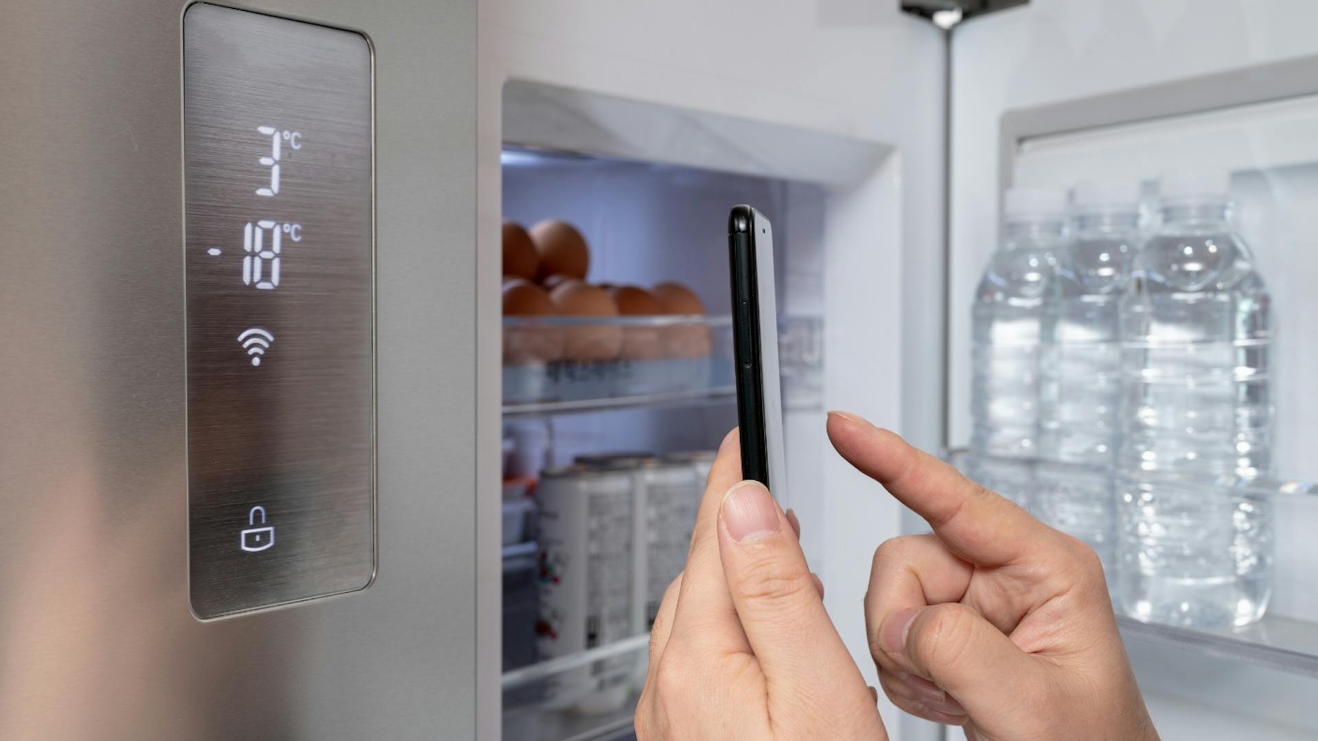 Smart Home Kühlschrank wird mit Smartphone-App bedient.